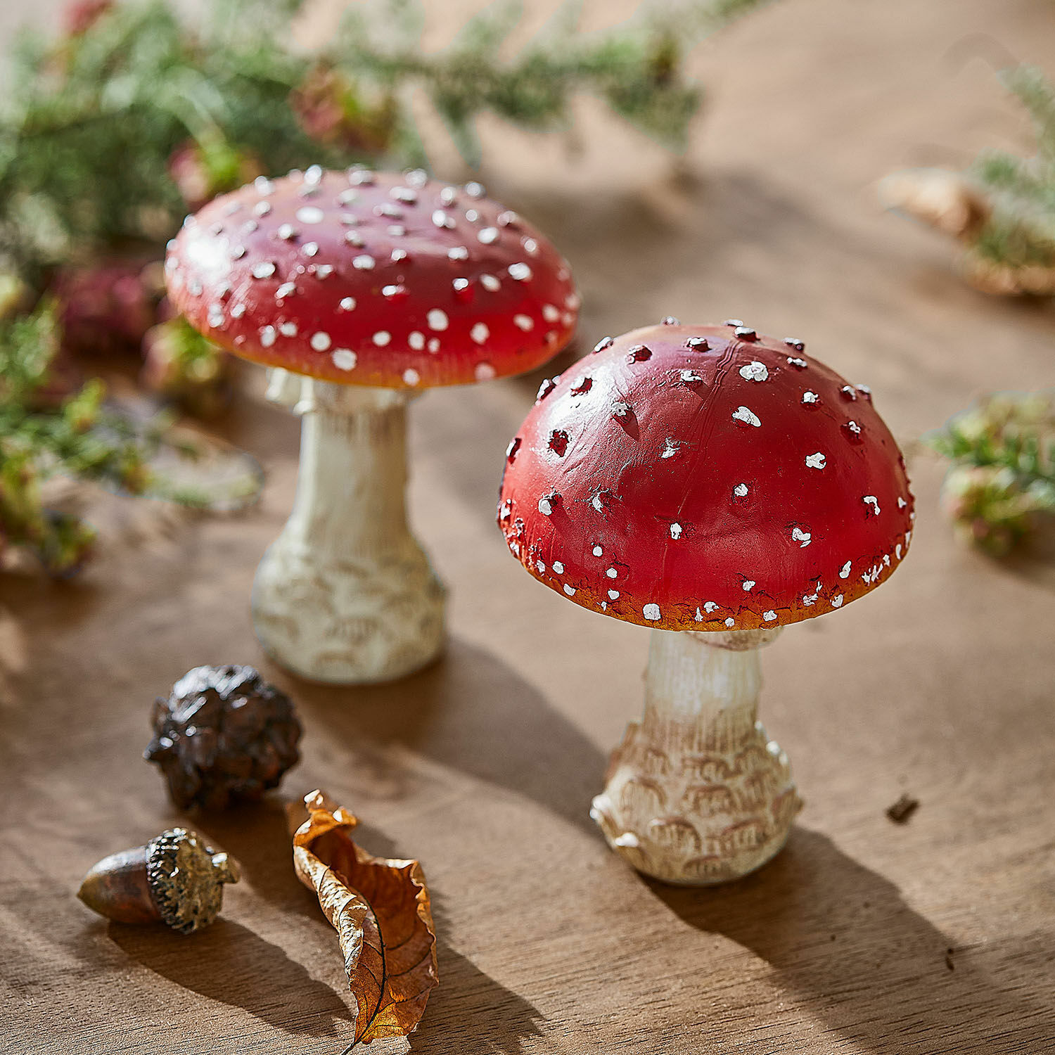 Lot de 2 champignons décoratifs Quintelle Champignons décoratifs rouges à pois blancs sur table en bois avec feuille et gland