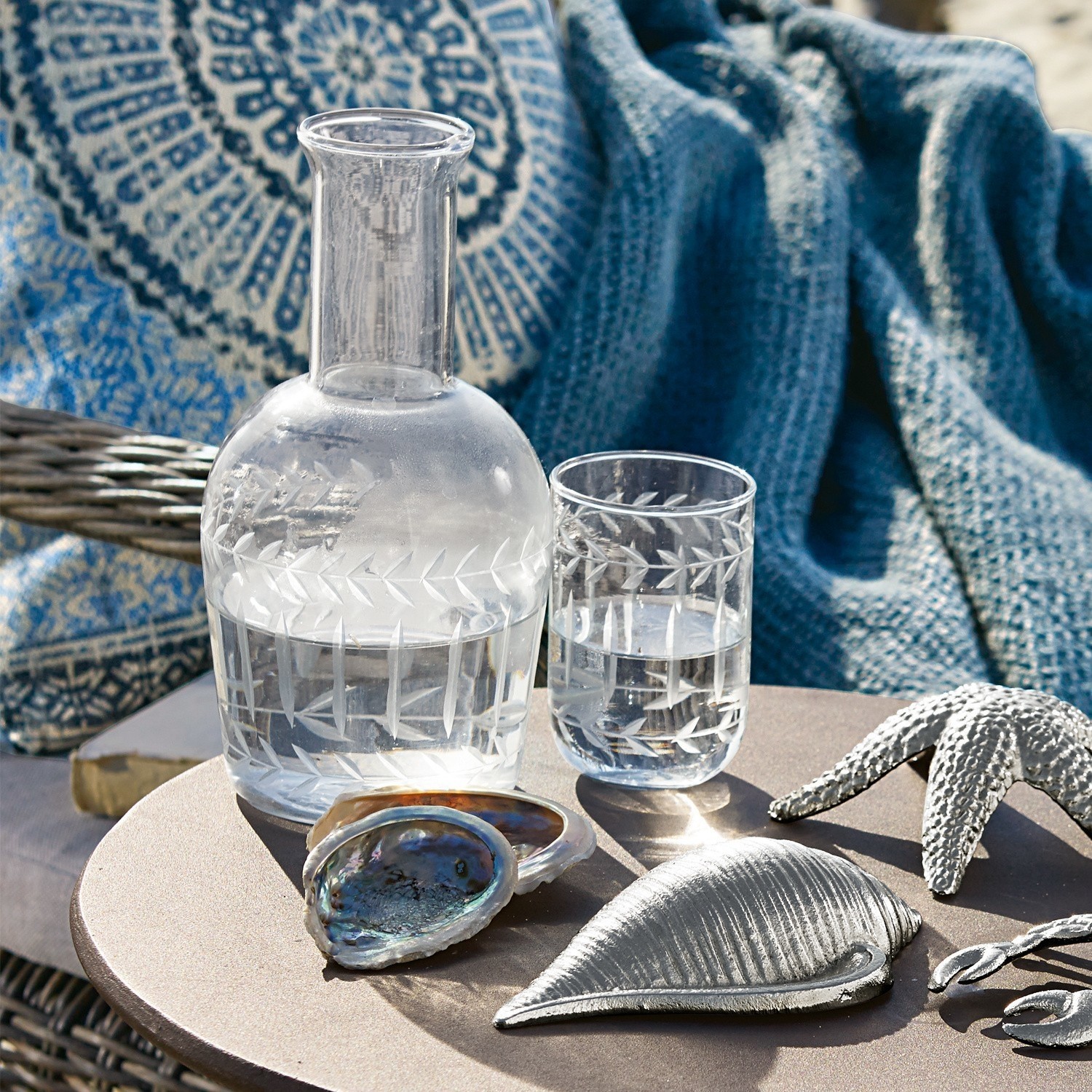 Carafe Mardor Carafe et verre en verre gravé sur table avec décorations coquillages et étoile de mer argentée