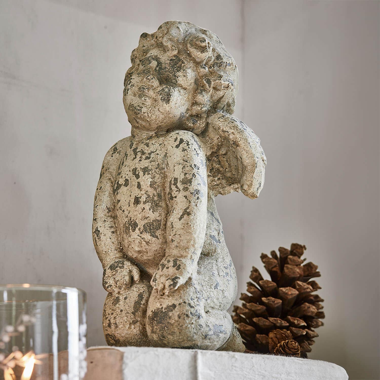 Statue d'ange en pierre vieillie beige, décoration intérieure avec pomme de pin naturelle