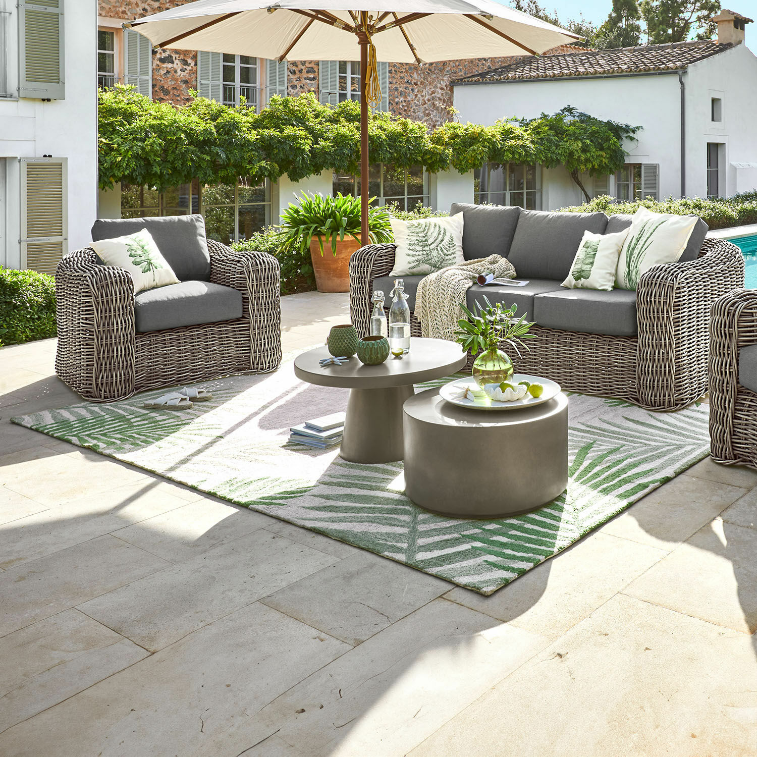 Tapis d'intérieur et d'extérieur Marly Ensemble de mobilier de jardin en technorattan gris avec coussins et parasol sur terrasse ensoleillée