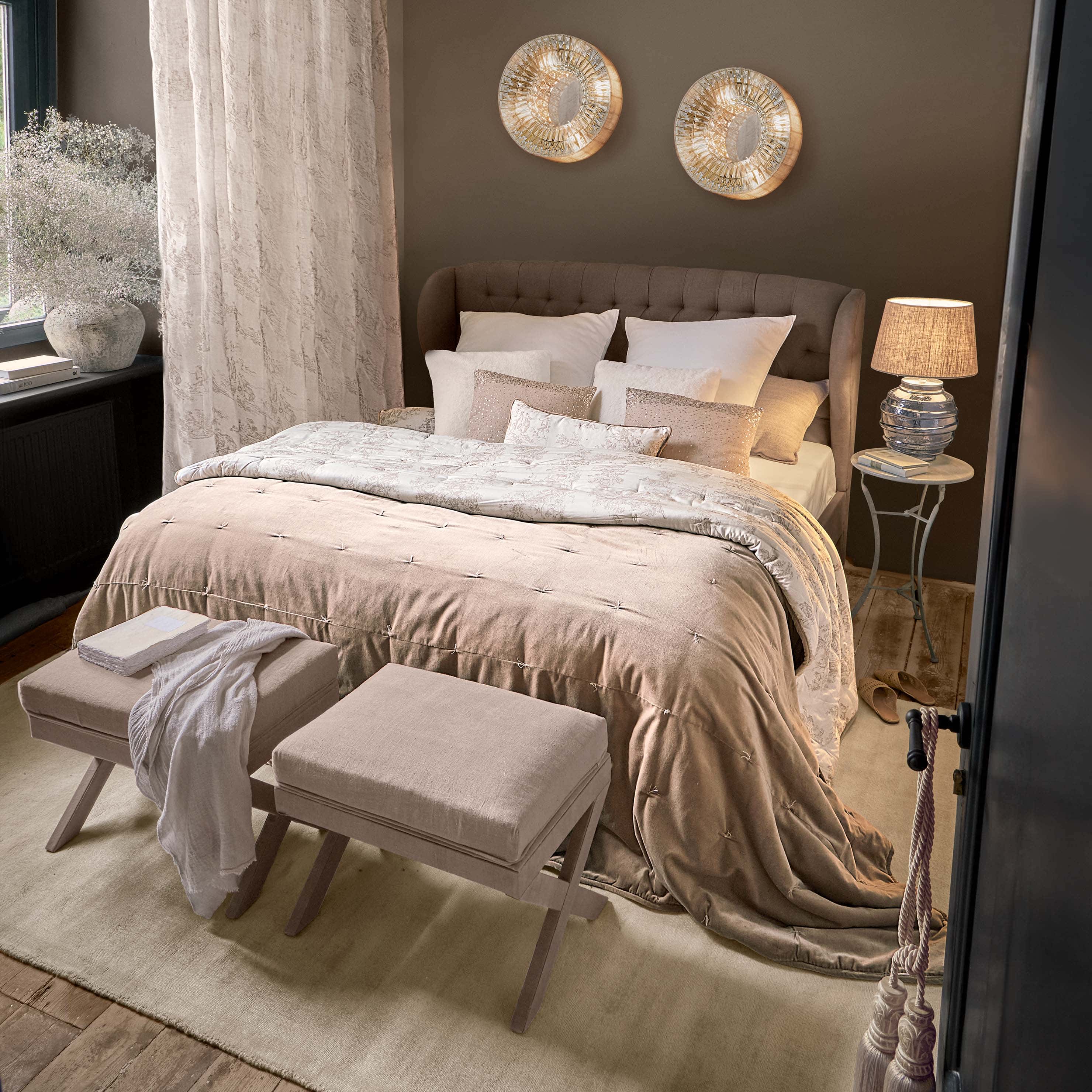 Chambre chaleureuse avec lit rembourré marron et literie beige avec coussins décoratifs assortis