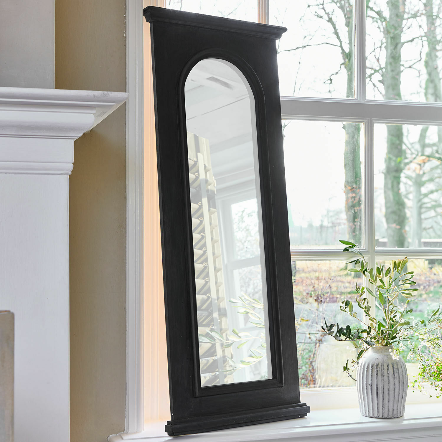 Miroir Timbercrest Miroir avec cadre en bois noir et bord supérieur arrondi posé sur le rebord de fenêtre