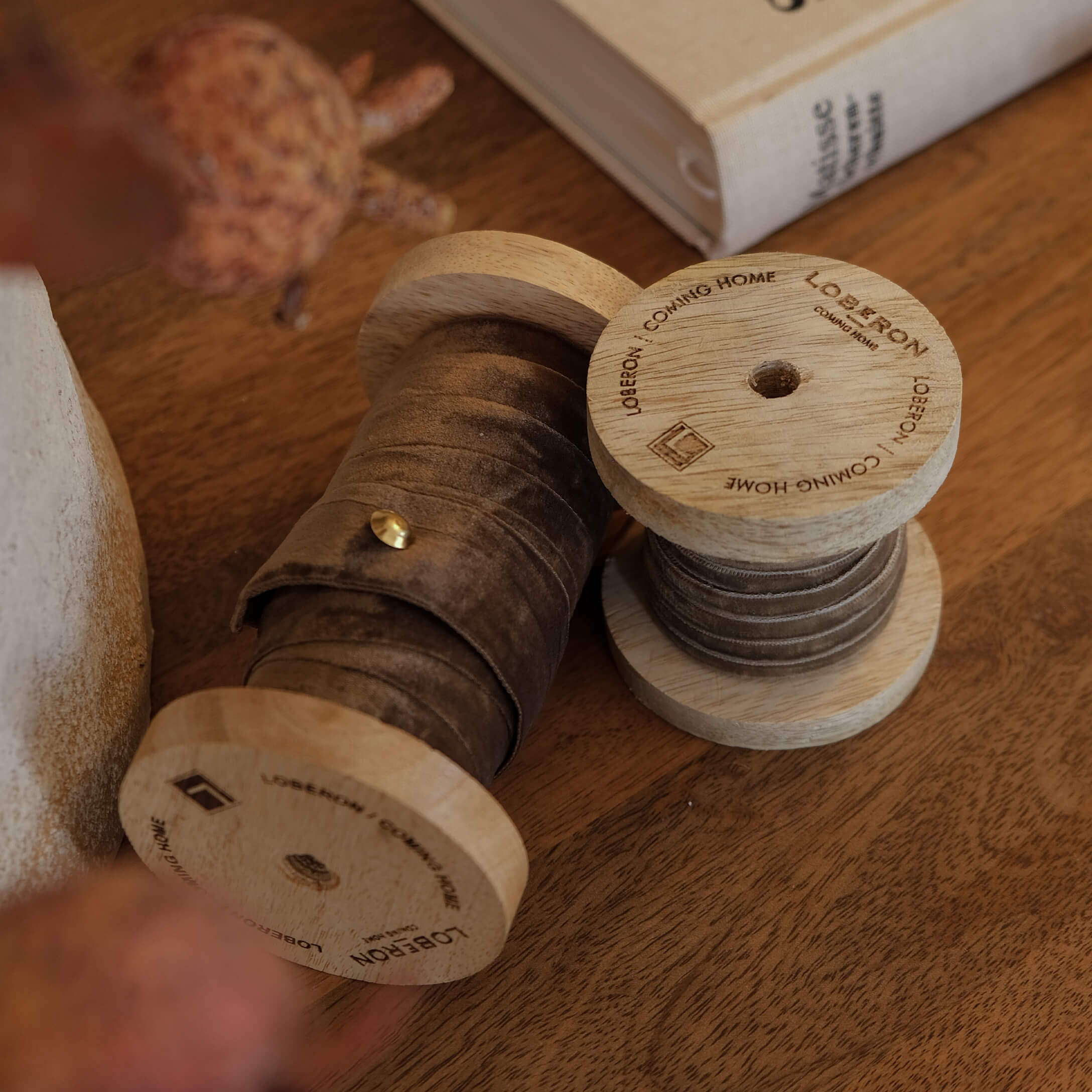 Bobines en bois avec ruban en velours marron sur table en bois, décoration intérieure cosy
