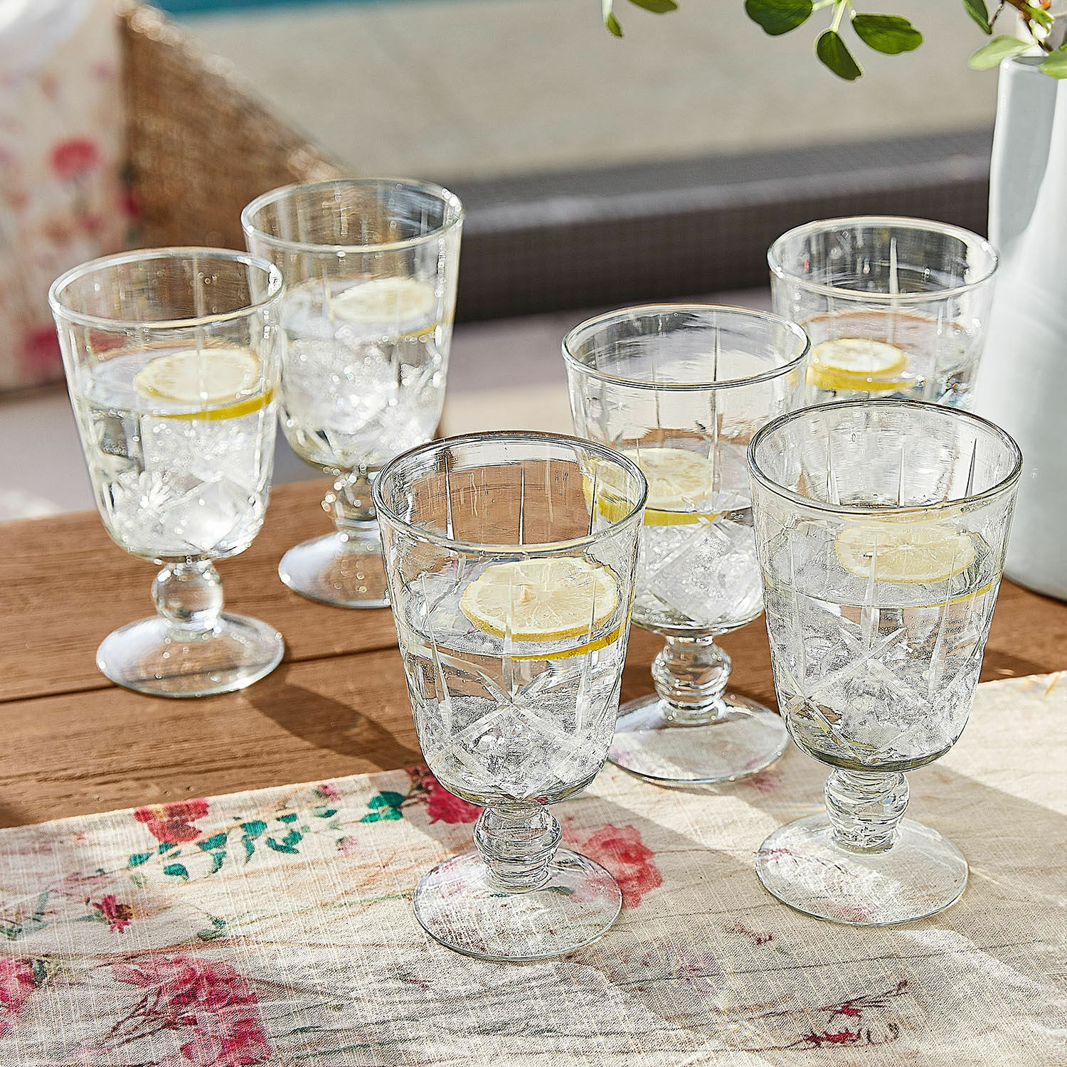 Lot de 6 verres Mirathor Ensemble de six verres transparents à pied avec eau, glaçons et tranche de citron sur table en bois