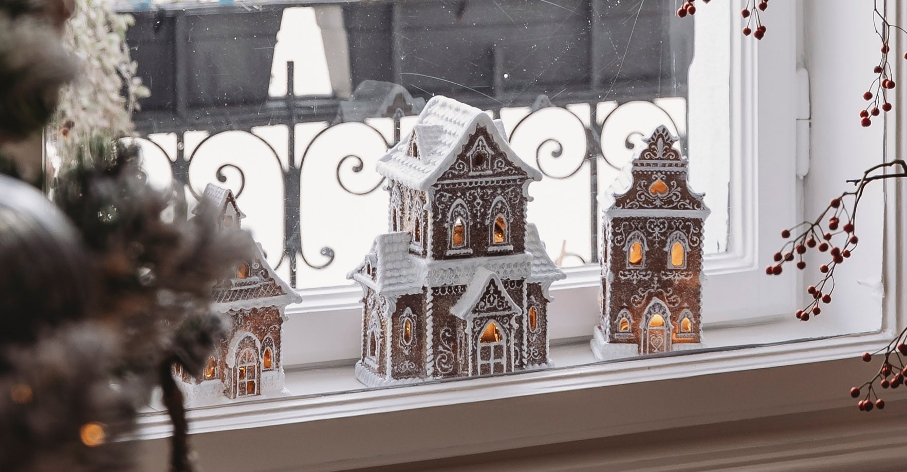 Maisons en pain d'épices décoratives avec glaçage blanc et éclairage sur le rebord de la fenêtre pour Noël