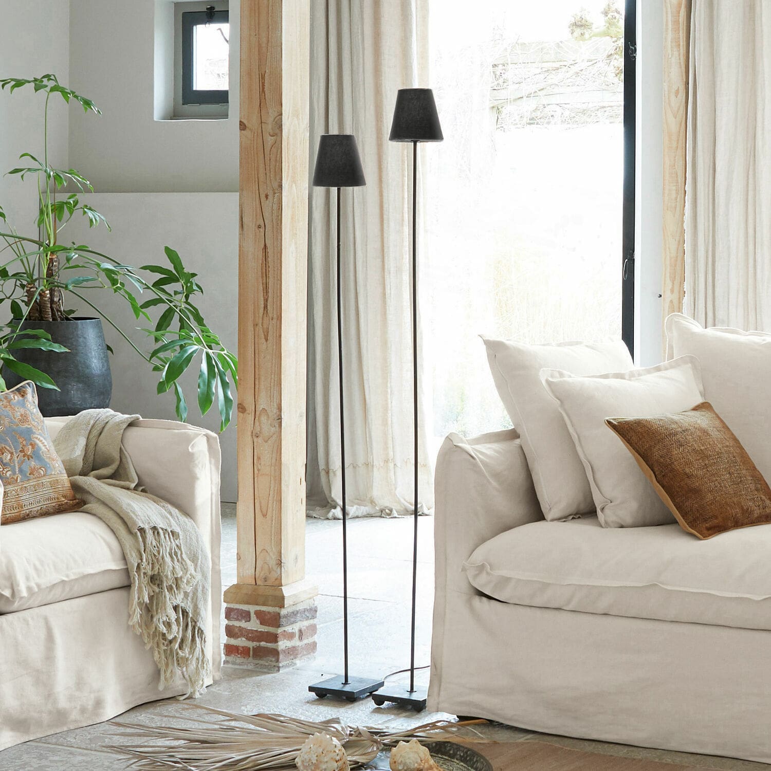Lot de 2 lampadaires Tacoma Deux lampes sur pied en métal noir dans un salon clair avec canapé beige et plante verte