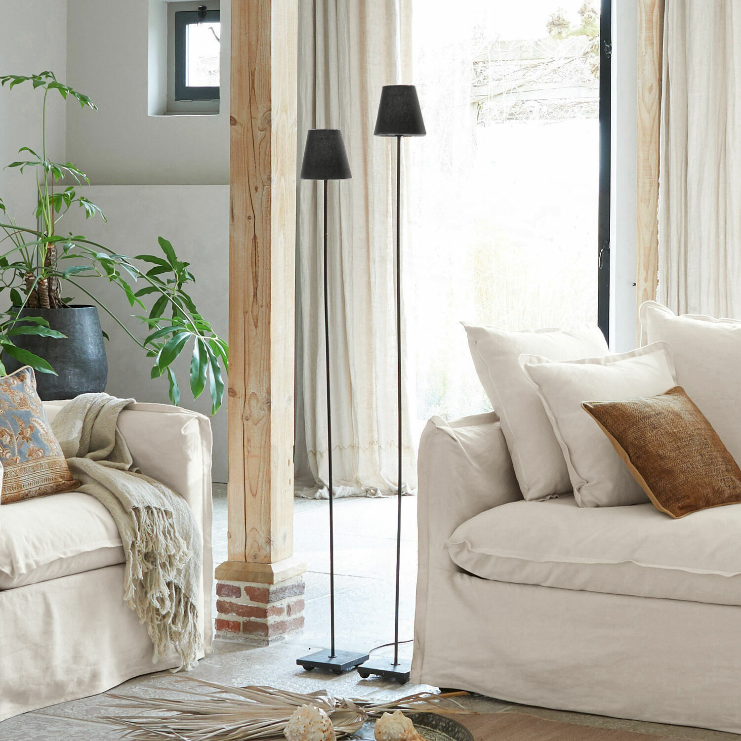 Lot de 2 lampadaires Tacoma Deux lampes sur pied en métal noir dans un salon clair avec canapé beige et plante verte