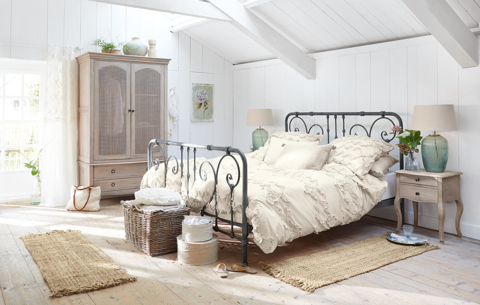 Chambre shabby chic avec lit en métal noir et linge de lit crème en coton, ambiance naturelle et cosy