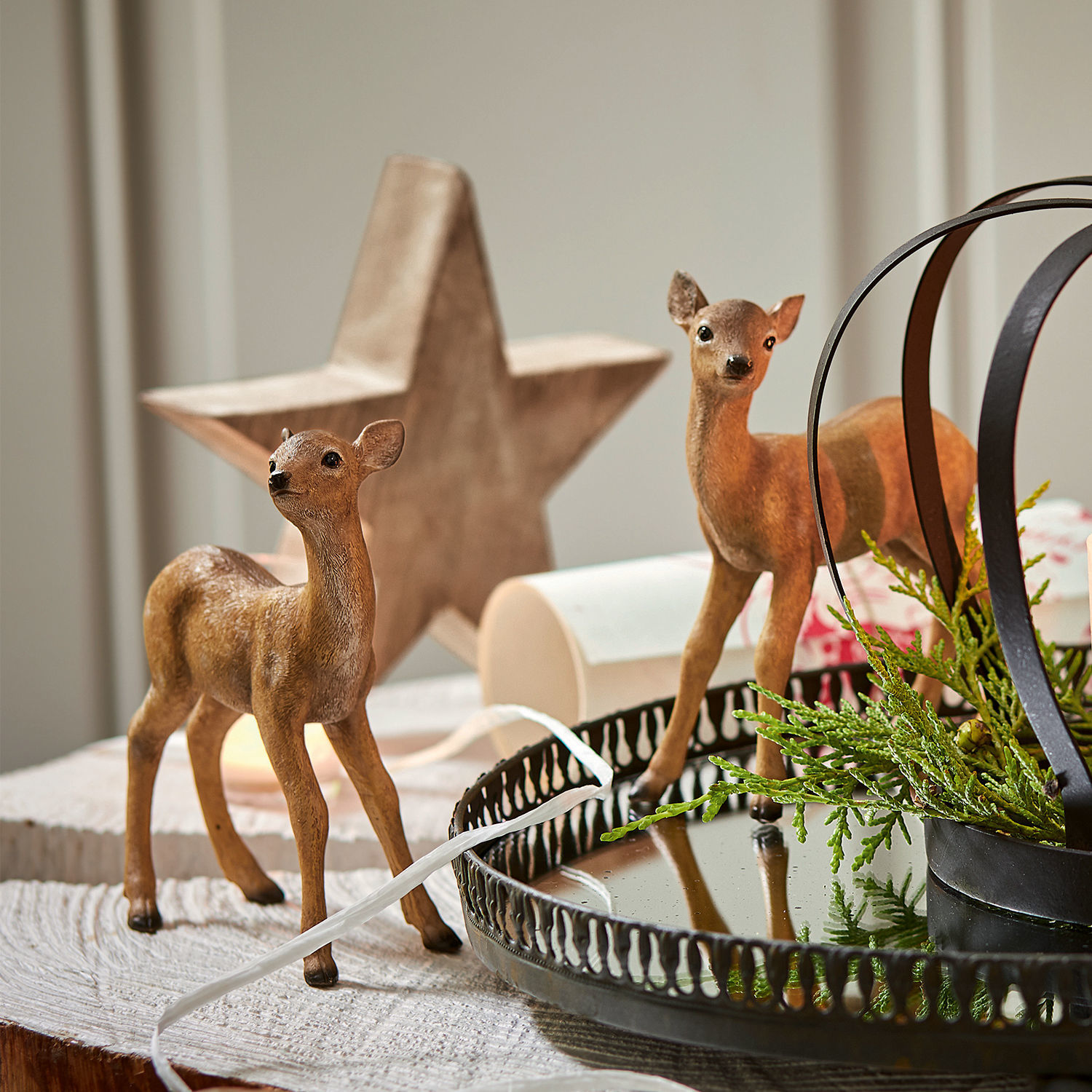 Lot de 2 faons Plantis Deux figurines de faons marron sur une table en bois avec un plateau en métal et des branches vertes décoratives