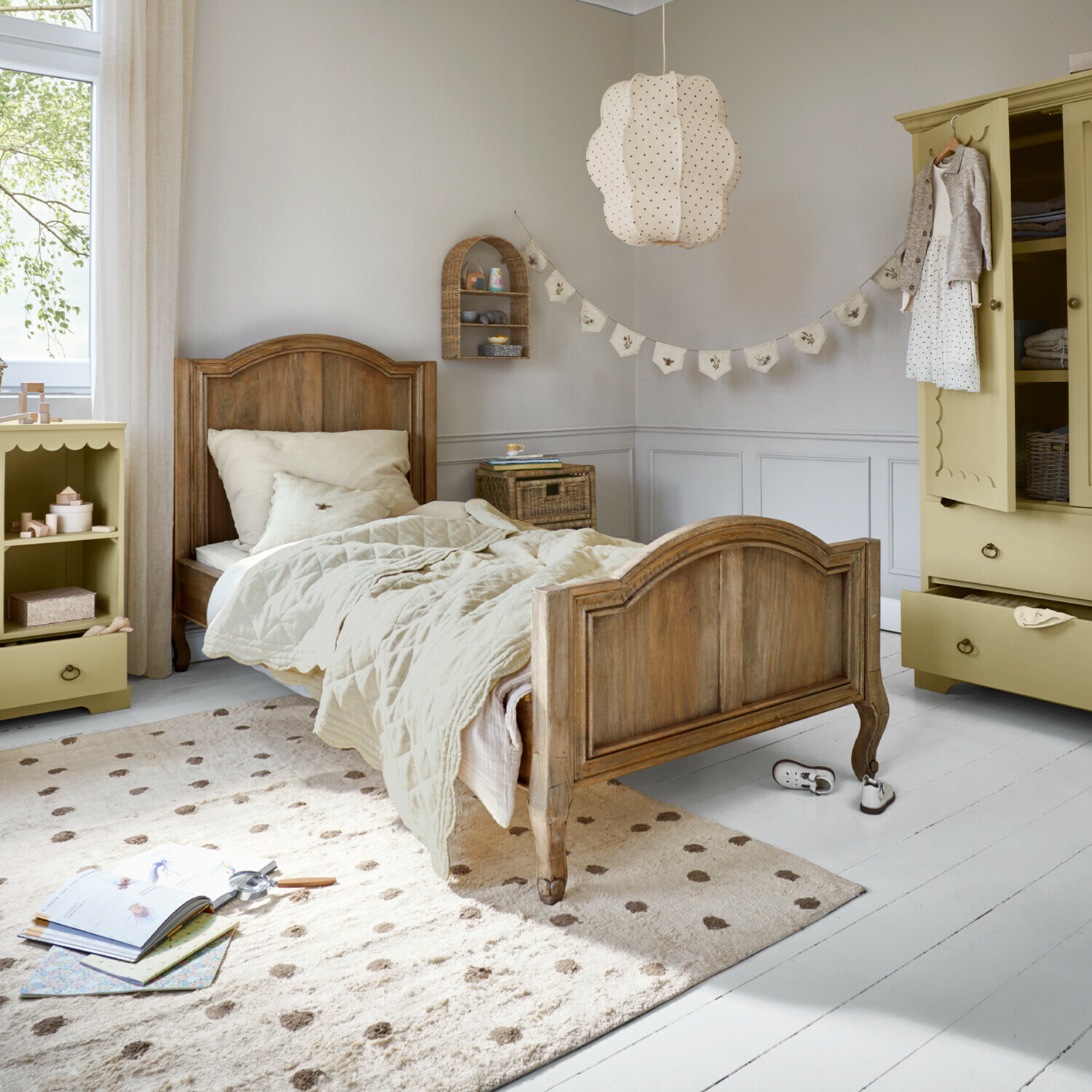 Lit Rêverine Lit enfant en bois avec literie beige et tapis crème dans une chambre lumineuse et décorée