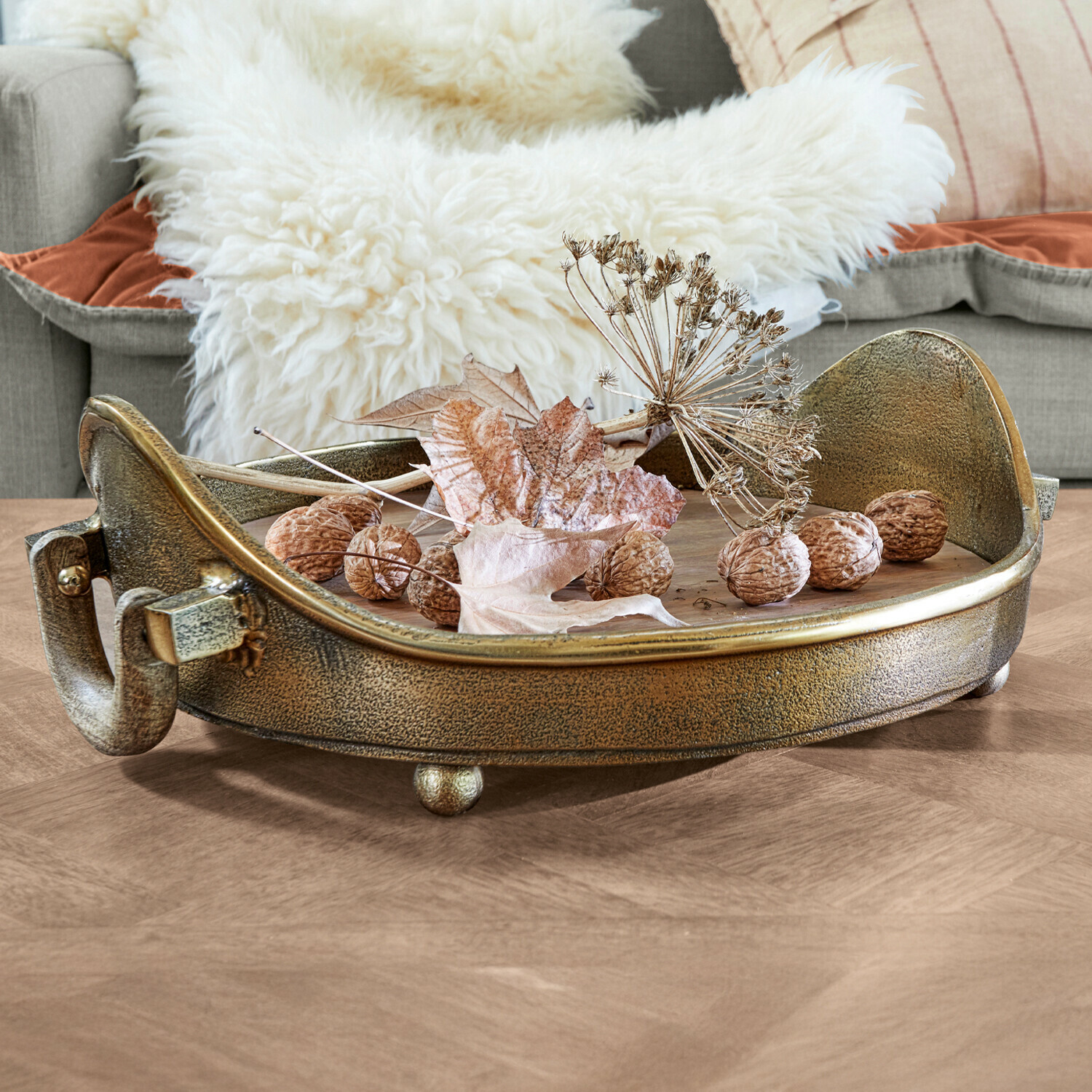 Plateau Louvil Plateau décoratif rond en métal couleur or ancien avec noix et feuilles sèches sur table en bois