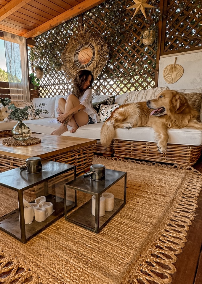 Salon cosy avec canapé en osier, tapis naturel, décorations en rotin et meubles en bois clair