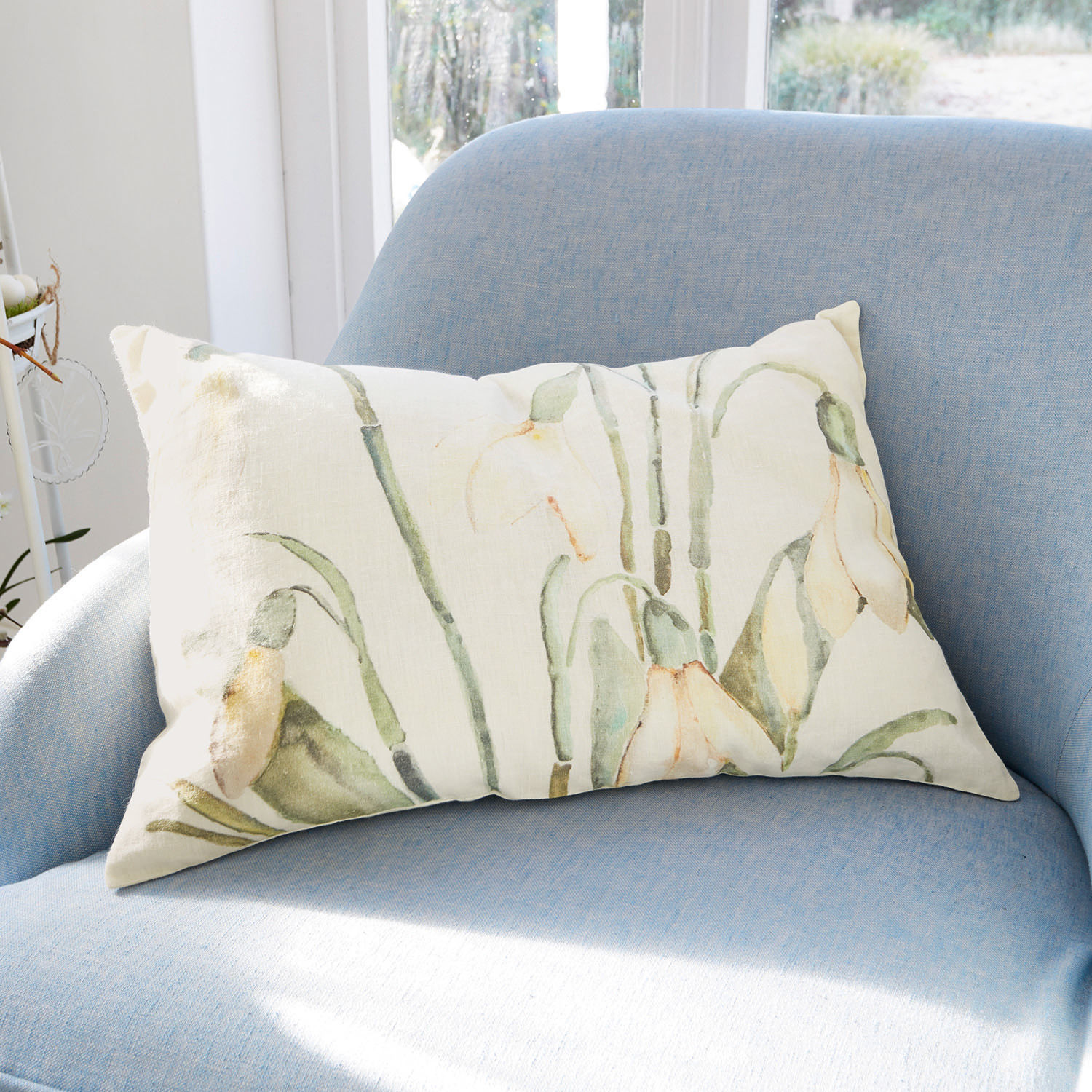 Housse de coussin Willmare Coussin décoratif rectangulaire en coton crème avec motifs floraux verts et jaunes sur fauteuil bleu