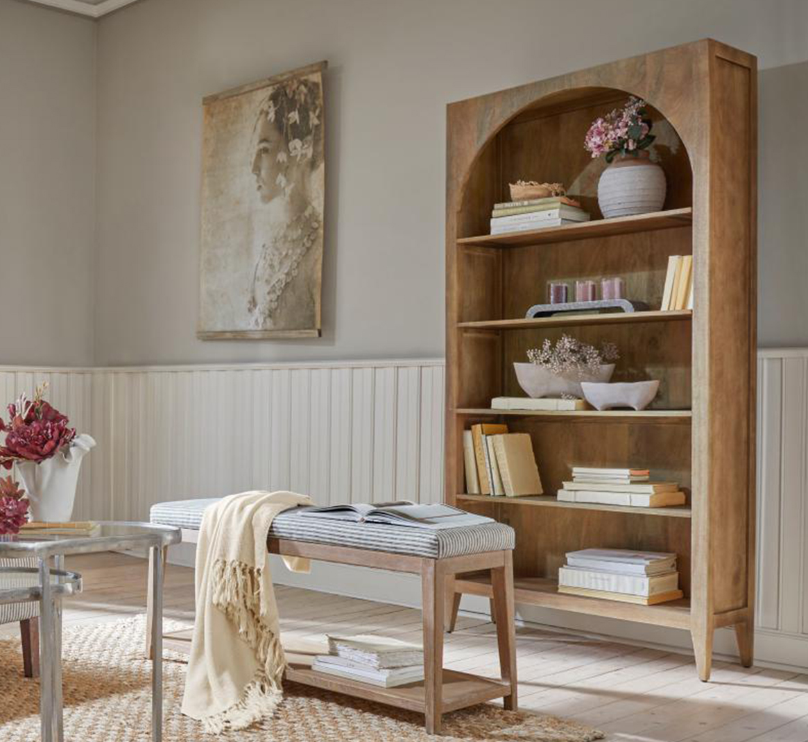 Bibliothèque en bois avec arche, décorations et livres dans un salon lumineux et naturel