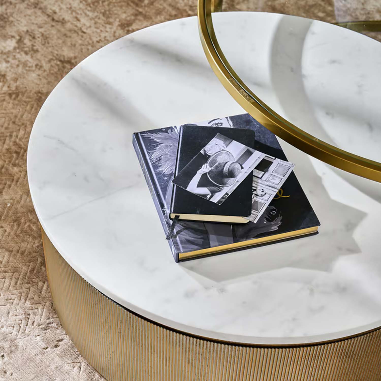 Table basse ronde avec plateau en marbre blanc et base dorée sur tapis beige