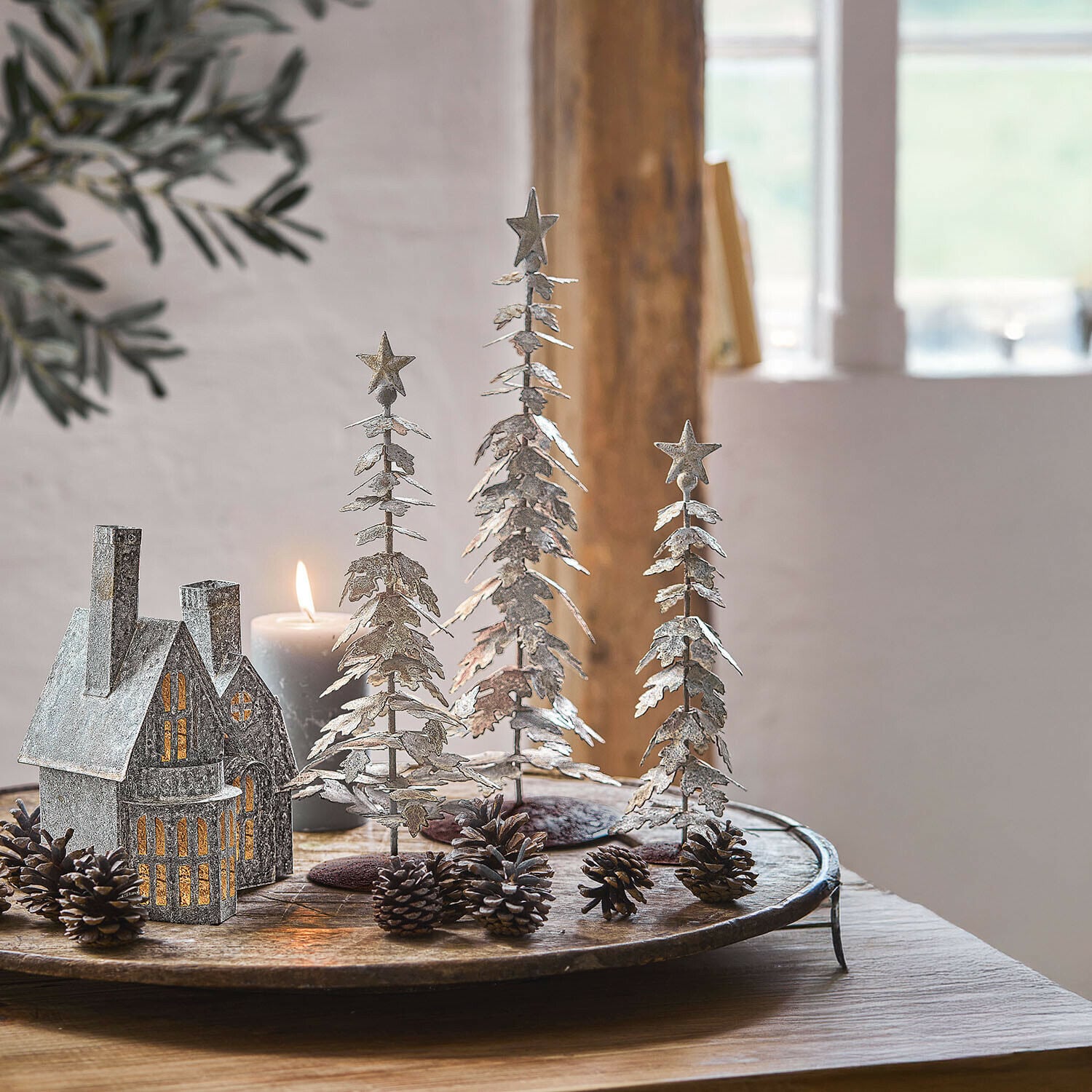 Lot de 3 arbres décoratifs Laruns Décorations de sapins en métal rouillé avec étoiles, posées sur une table en bois rustique