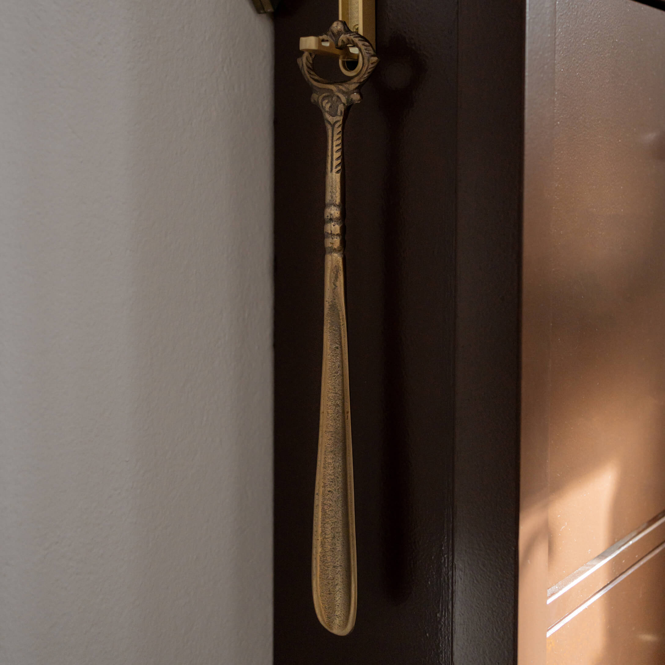 Chausse-pied en métal doré avec poignée décorative, accessoire pratique pour la maison