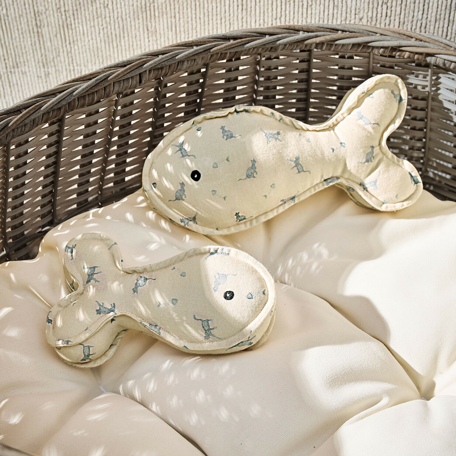 Coussins beige en forme de poisson avec imprimé de chats sur fauteuil en osier avec coussin clair