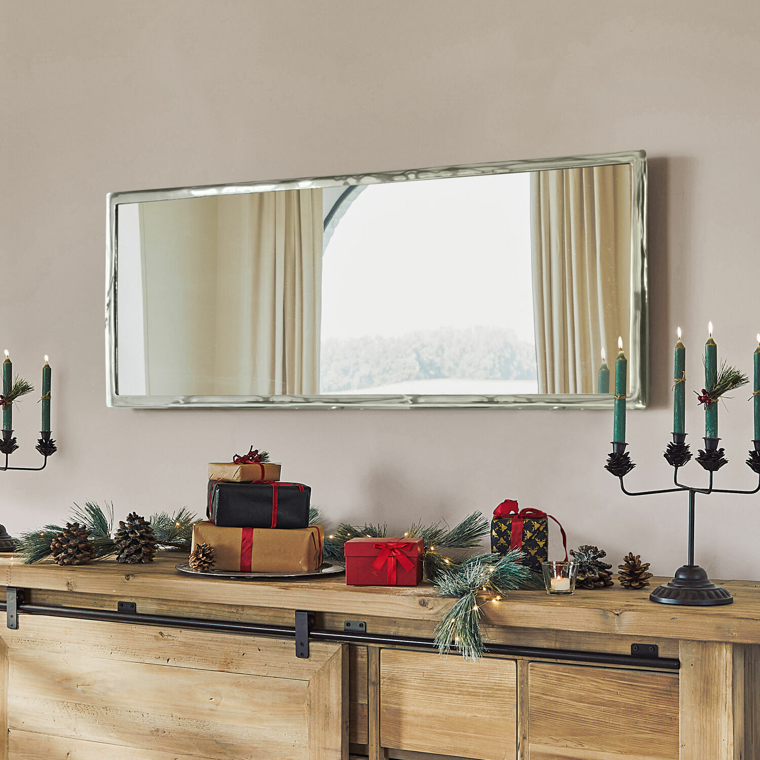 Miroir Kaplin Miroir rectangulaire à cadre métallique argenté au-dessus d'un buffet en bois décoré pour Noël