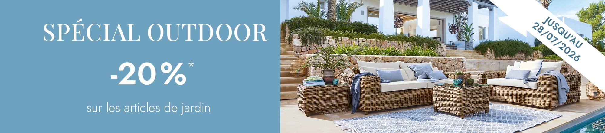 Ensemble de mobilier de jardin en rotin naturel avec coussins crème et tapis bleu près de la piscine