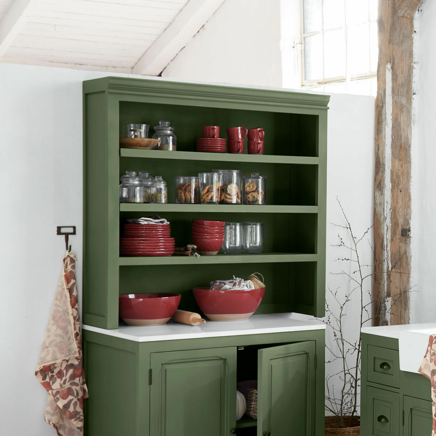 Étagère de cuisine haute Lansbury Buffet vert en bois avec bols rouges en céramique et bocaux en verre remplis de biscuits dans une cuisine rustique