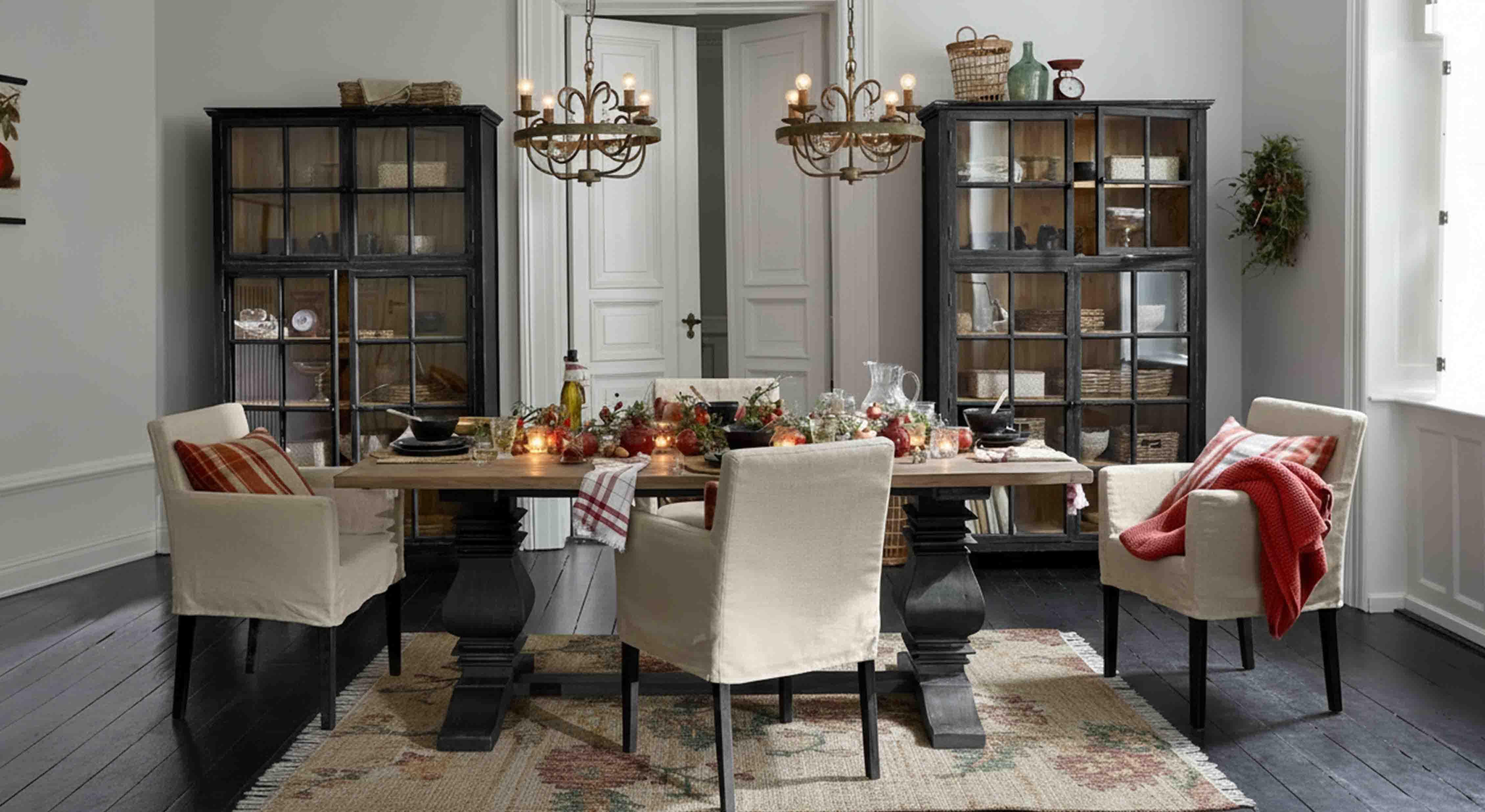 Salle à manger avec table en bois et chaises crème, décor rustique avec luminaires suspendus