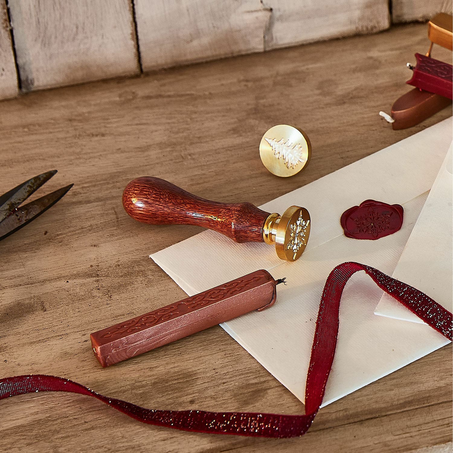 Cachet de cire Movique Ensemble de sceaux avec manche en bois et cire rouge sur des enveloppes posées sur une table en bois