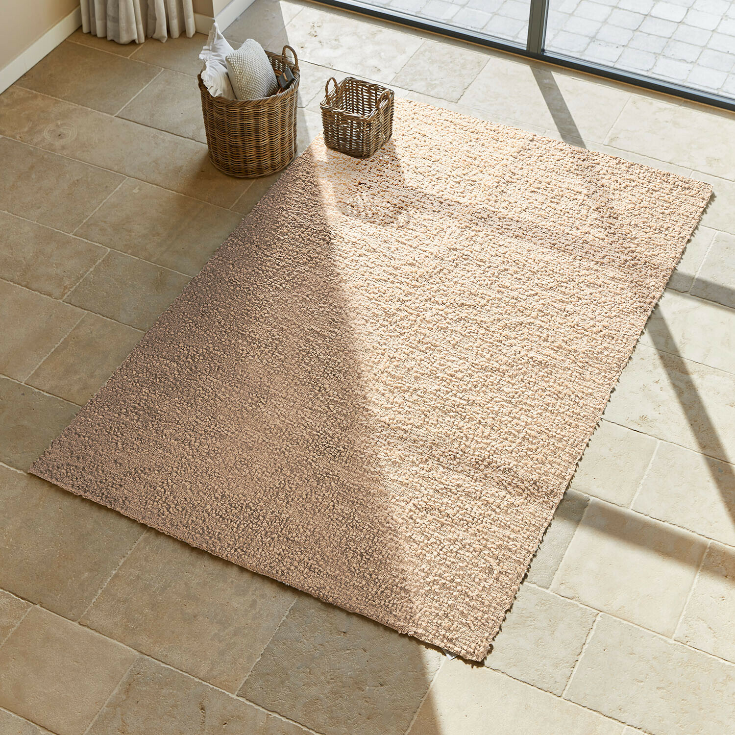 Tapis beige en matériau doux sur sol en pierre claire, décoratif et confortable pour intérieur