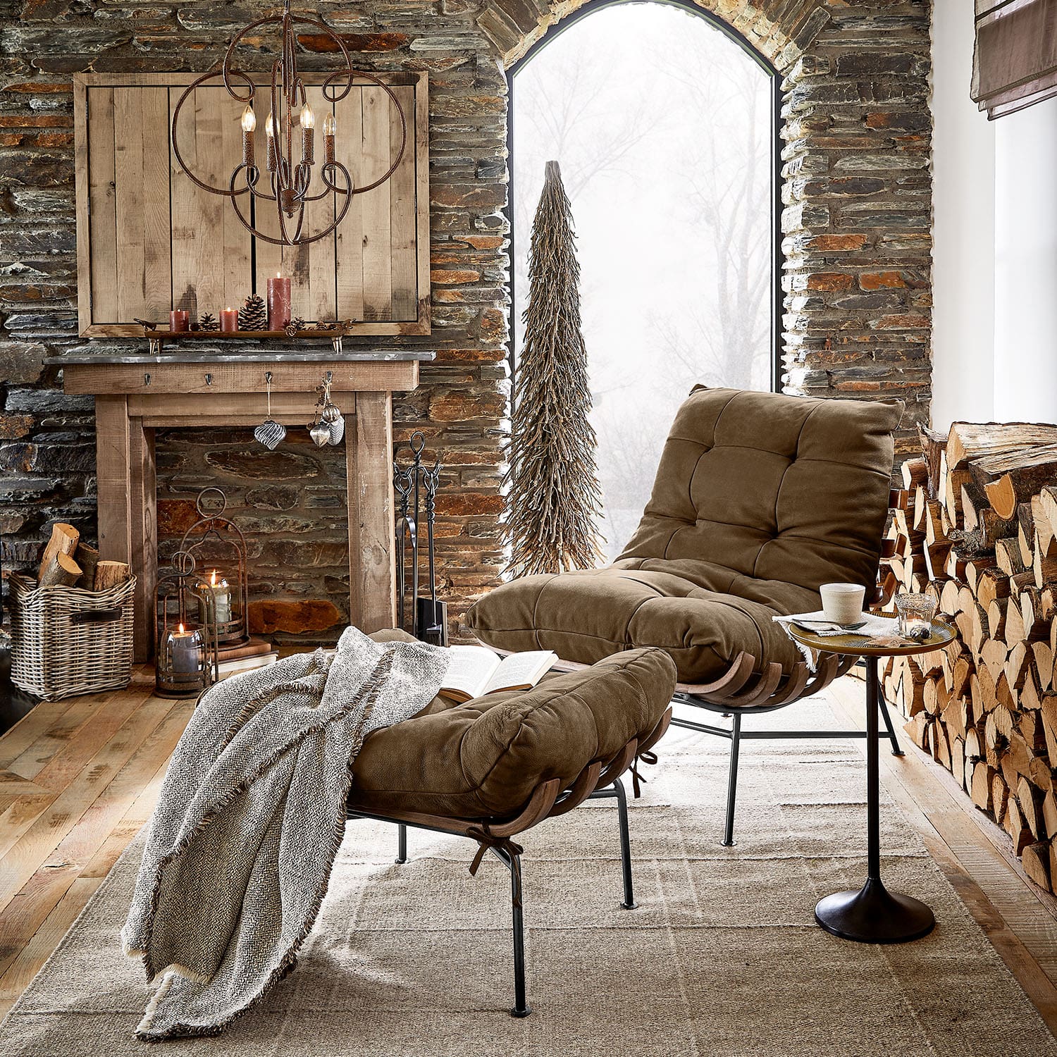Fauteuil marron avec repose-pieds et cadre en métal dans un salon rustique avec cheminée et bois