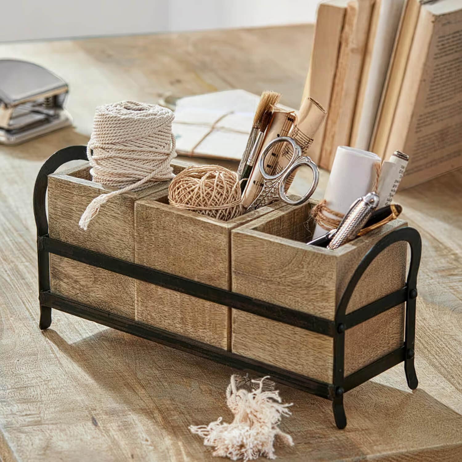 Organisateur de bureau en bois à trois compartiments avec cadre en métal contenant des fournitures et cordons