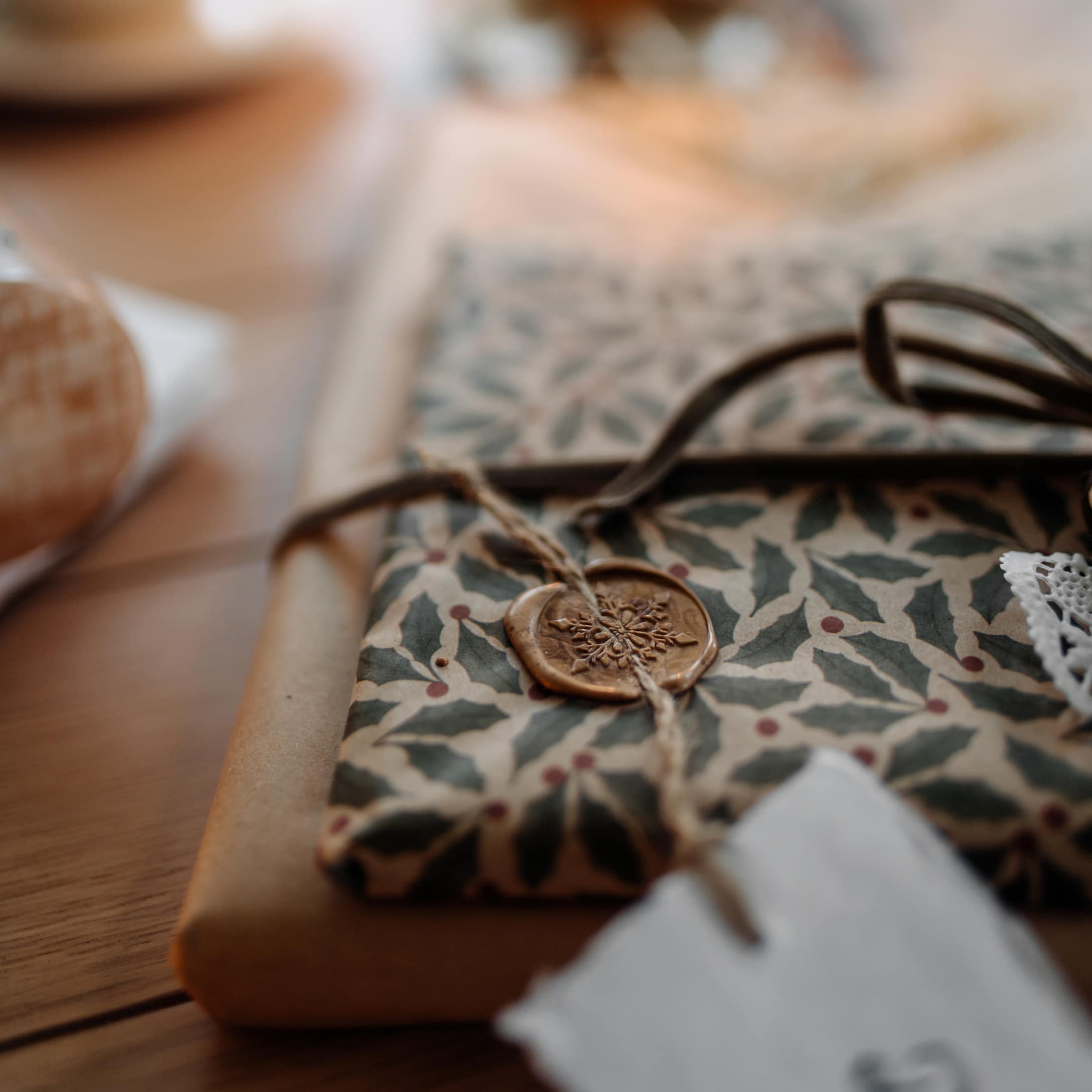 Emballage cadeau élégant avec papier à motifs de feuilles et sceau de cire sur ficelle