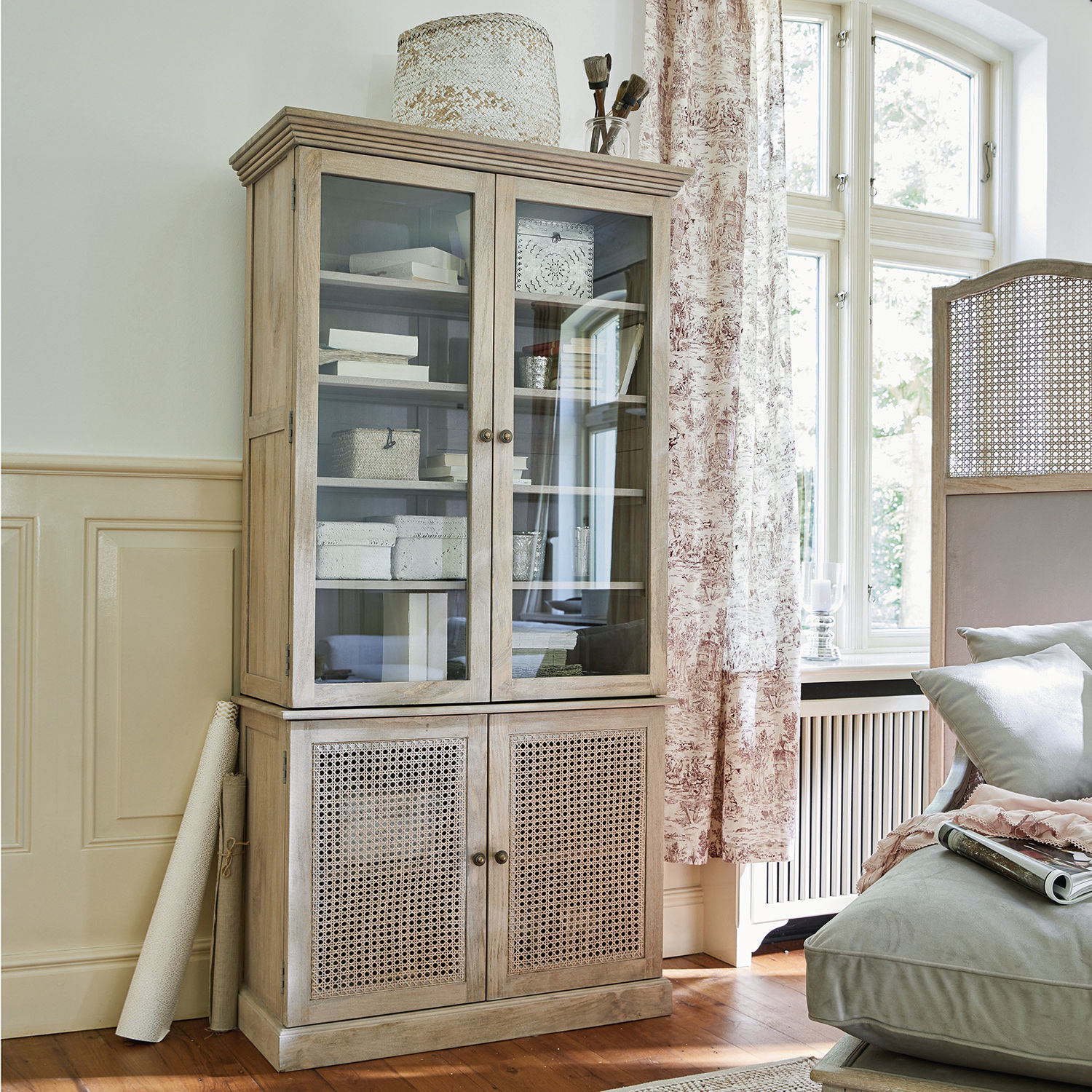Armoire Dronne Vitrine en bois clair avec portes vitrées et en osier pour un salon lumineux et élégant