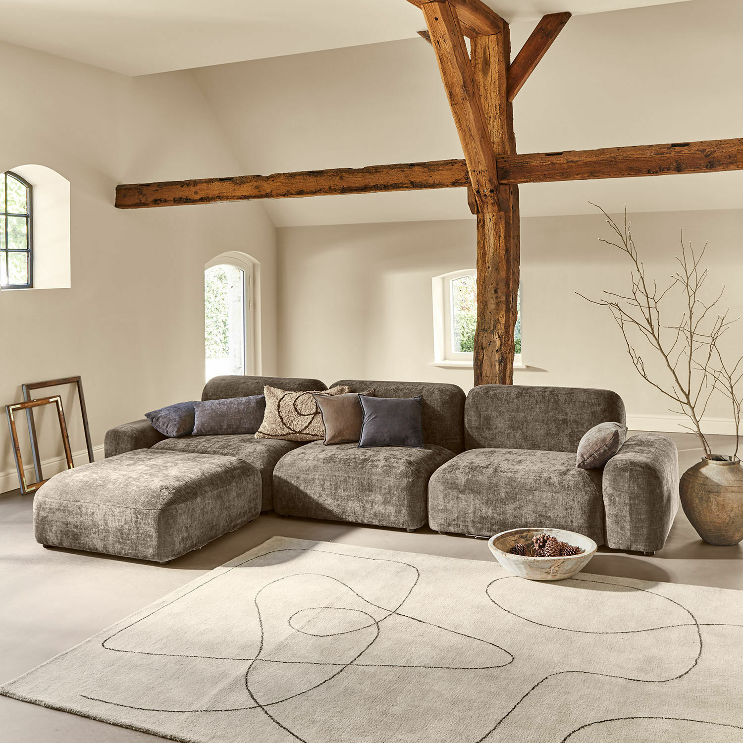 Canapé Marnivelle Canapé modulaire gris en tissu dans un salon moderne avec poutres en bois et tapis clair