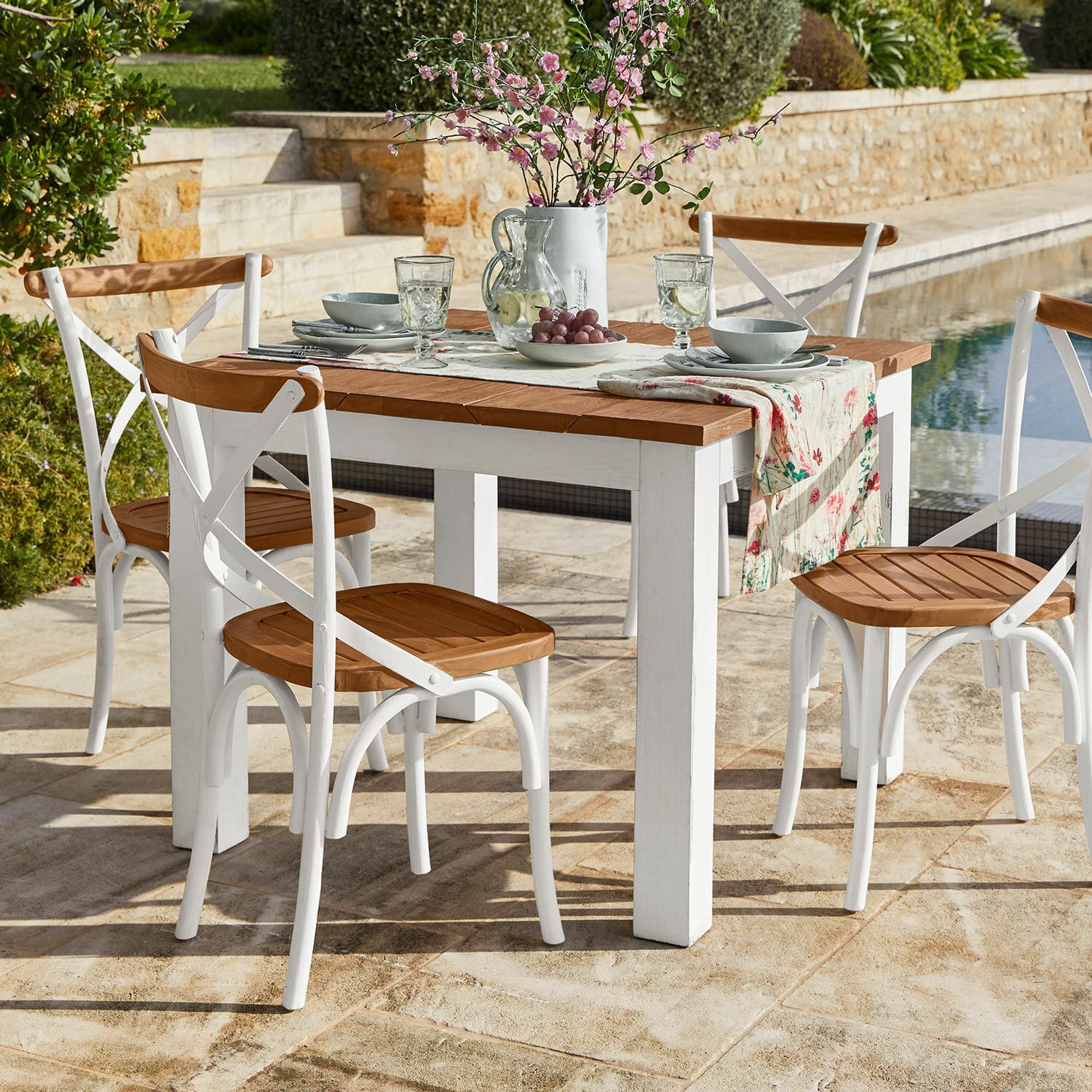 Table Kirkdale Ensemble de mobilier de jardin avec table blanche en bois et chaises à assise en bois sur terrasse en pierre