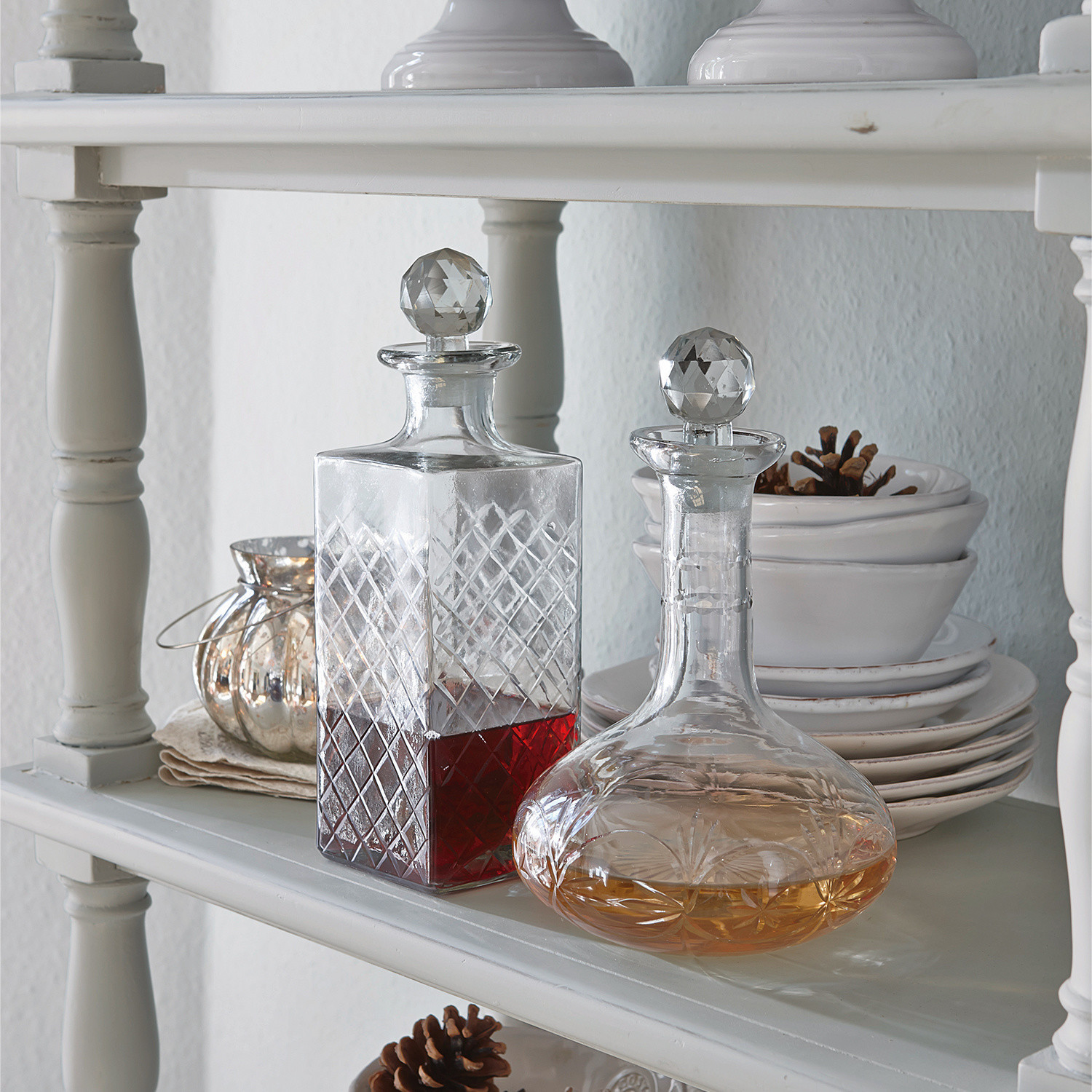 Lot de 2 carafes Dairine Carafes en verre avec bouchons en cristal sur étagère blanche avec boissons rouge et ambrée
