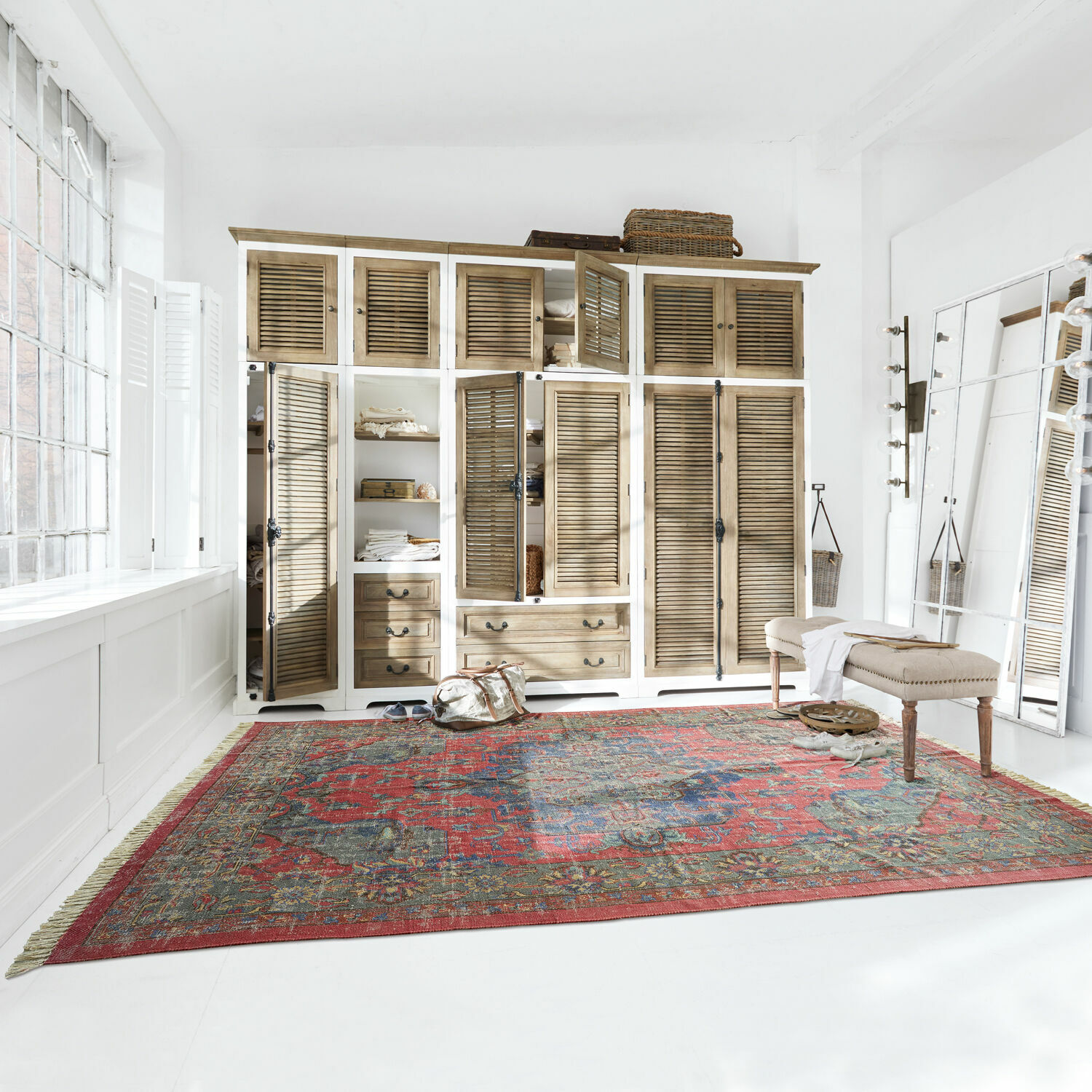 Tapis Southampton Grand tapis rouge à motif oriental dans une pièce claire avec armoire en bois et banc