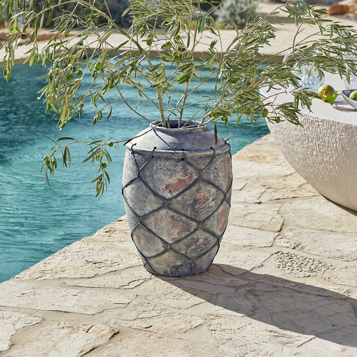 Vase Deloriva Grand vase en céramique grise avec filet décoratif sur terrasse en pierre près de la piscine