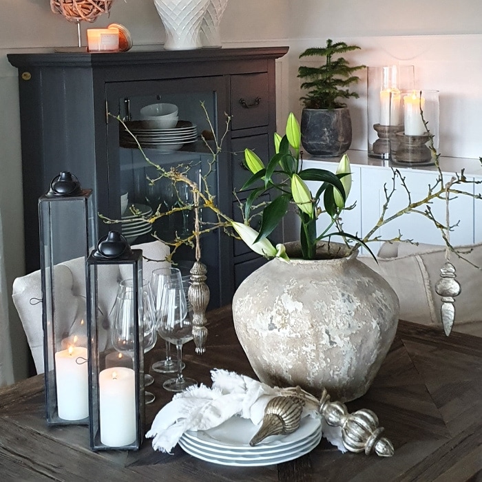Table décorative avec grand vase en céramique beige et bougies dans des lanternes en verre