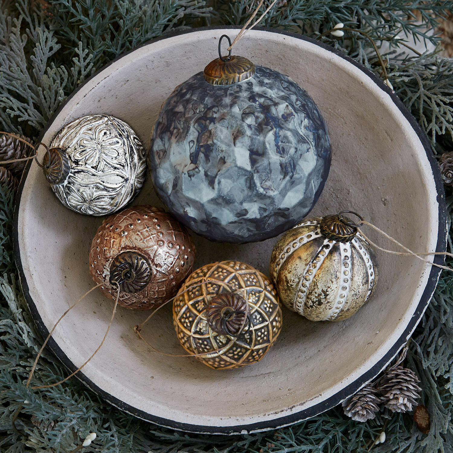 Lot de 5 décorations de Noël Jilian Boules de Noël décoratives en métal multicolores dans un bol en céramique sur fond vert