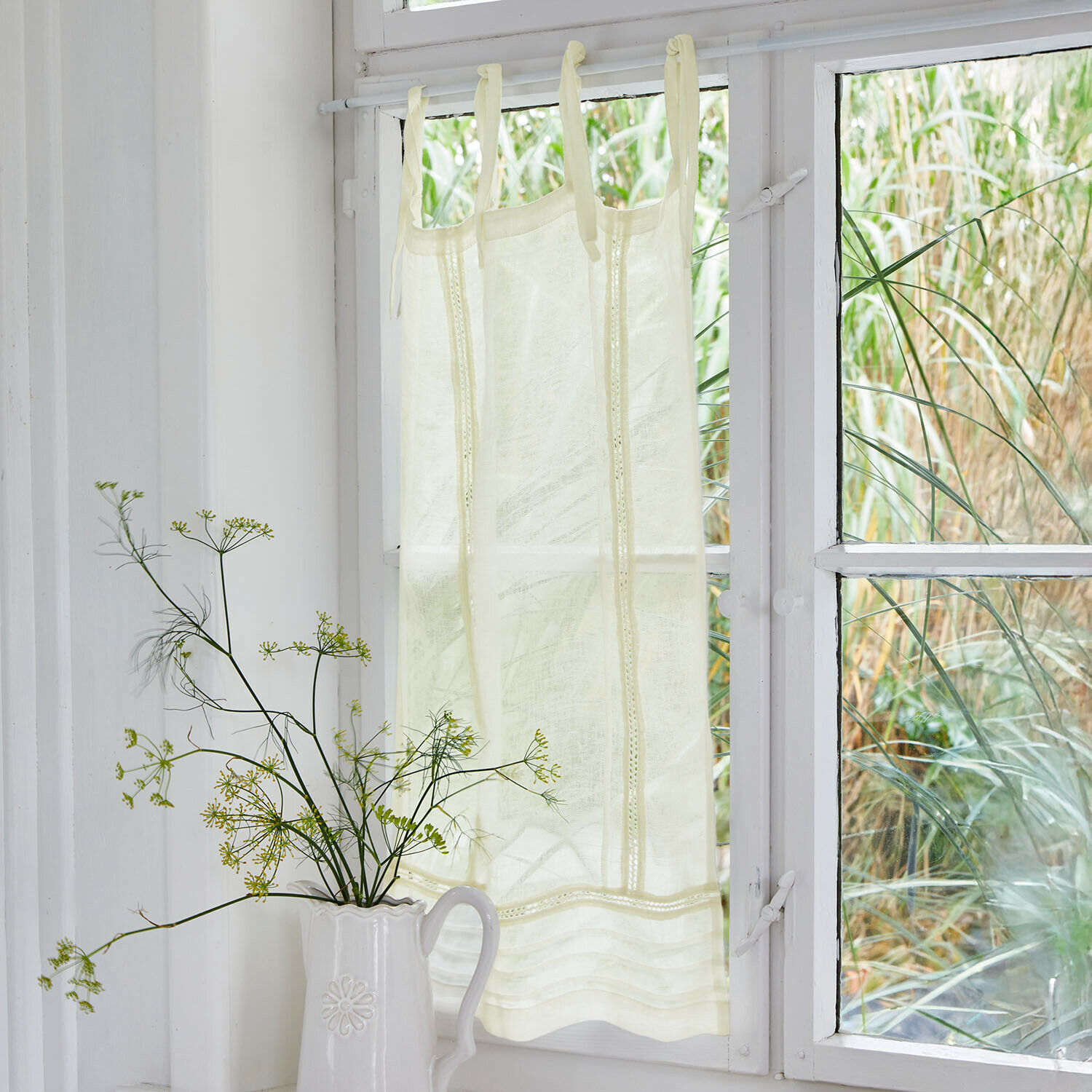 Brise-bise Jolivane Rideau crème en tissu léger avec bandes décoratives suspendu à une fenêtre blanche, décoration intérieure