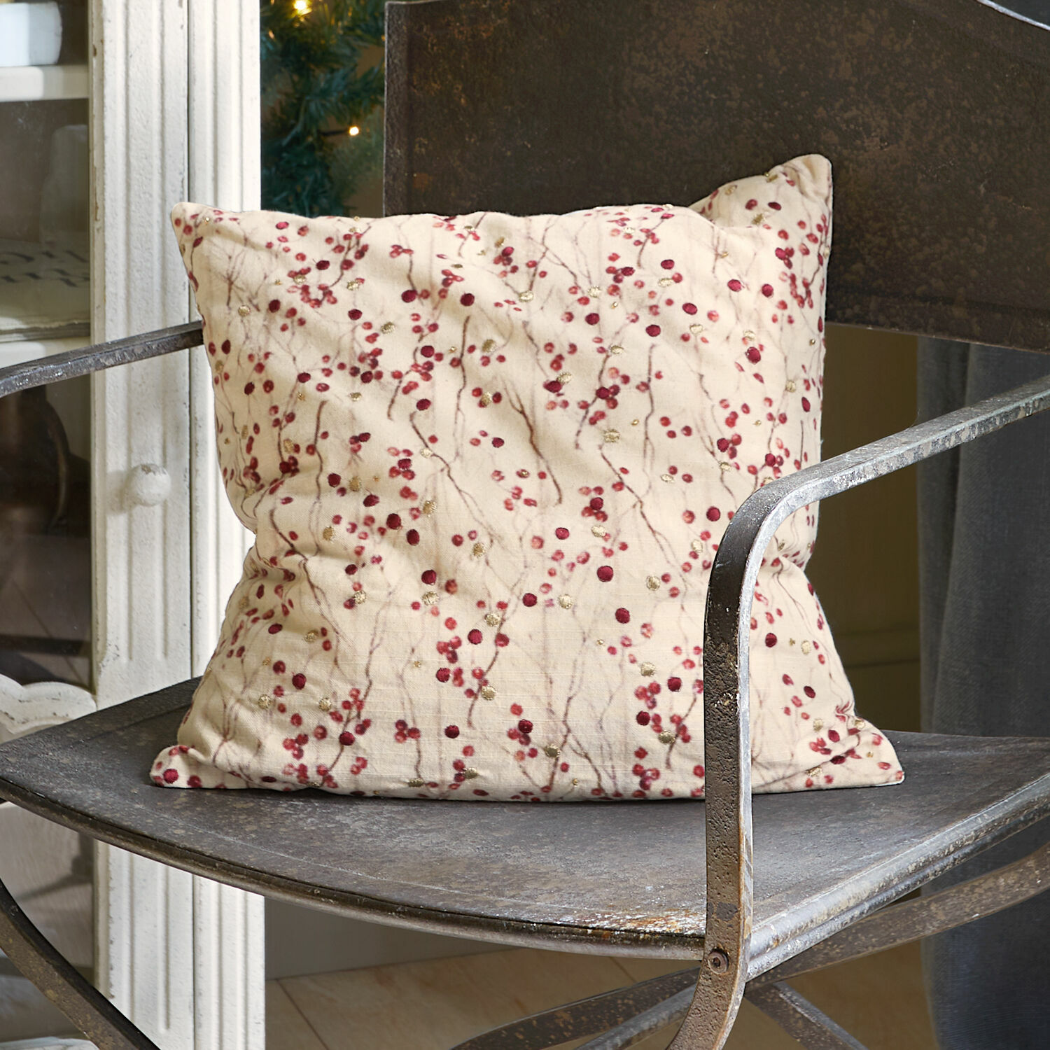 Housse de coussin Rimont Coussin beige à motifs rouges posé sur une chaise en métal au style vintage pour décoration intérieure