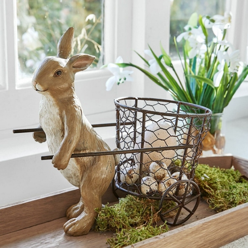 Lapin décoratif en métal brun avec panier contenant des œufs et une bougie, décoration printanière