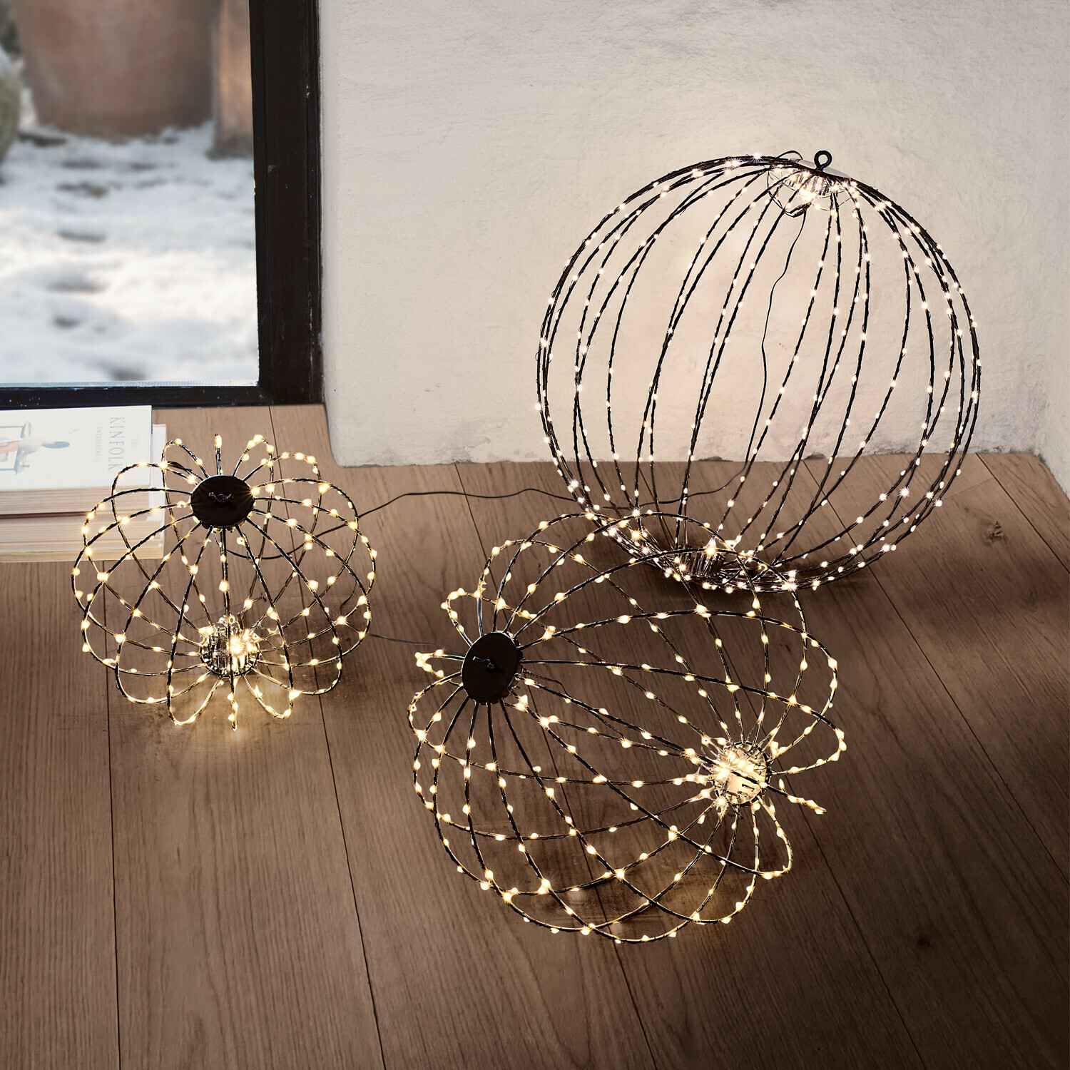Deux sphères lumineuses LED décoratives blanches chaudes posées au sol dans un salon moderne