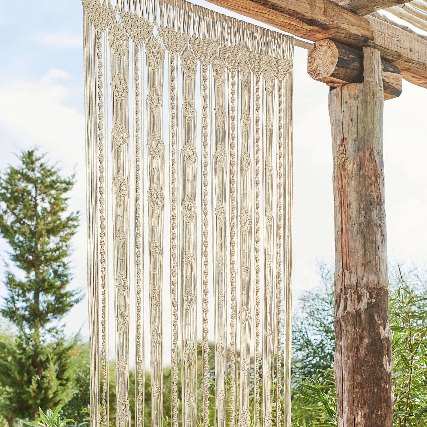 Rideau Arjun Macramé beige en coton suspendu sur une structure en bois, décoration murale pour intérieur et jardin