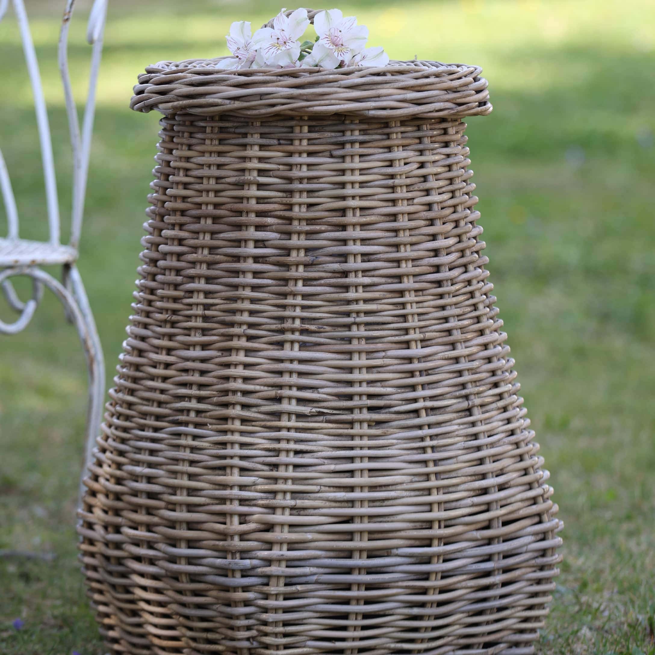 Panier rond en rotin couleur naturelle avec fleurs sur le dessus, décoration de jardin