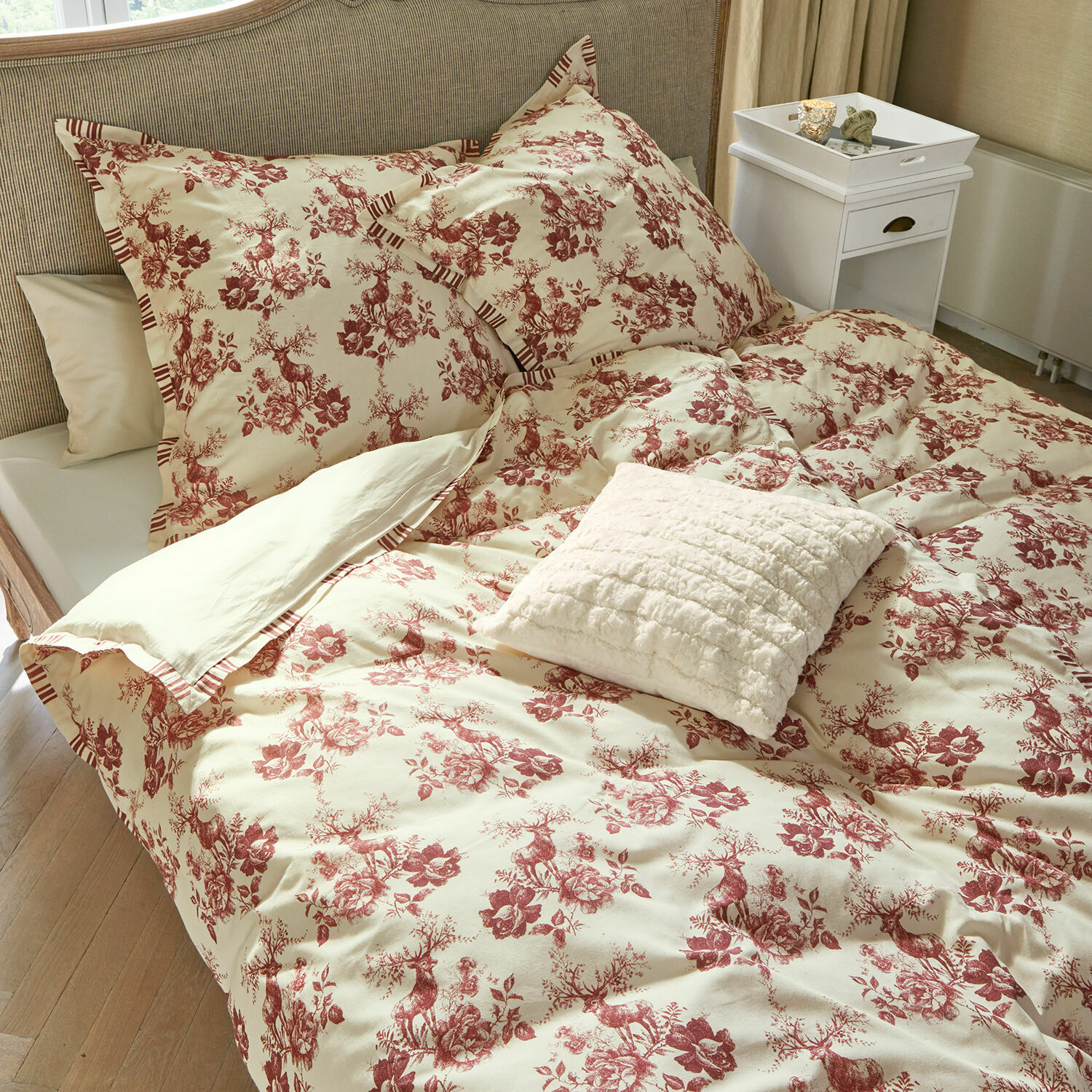 Parure de lit Renique Parure de lit en coton crème avec motif rouge de cerfs et fleurs, coussin décoratif sur le lit