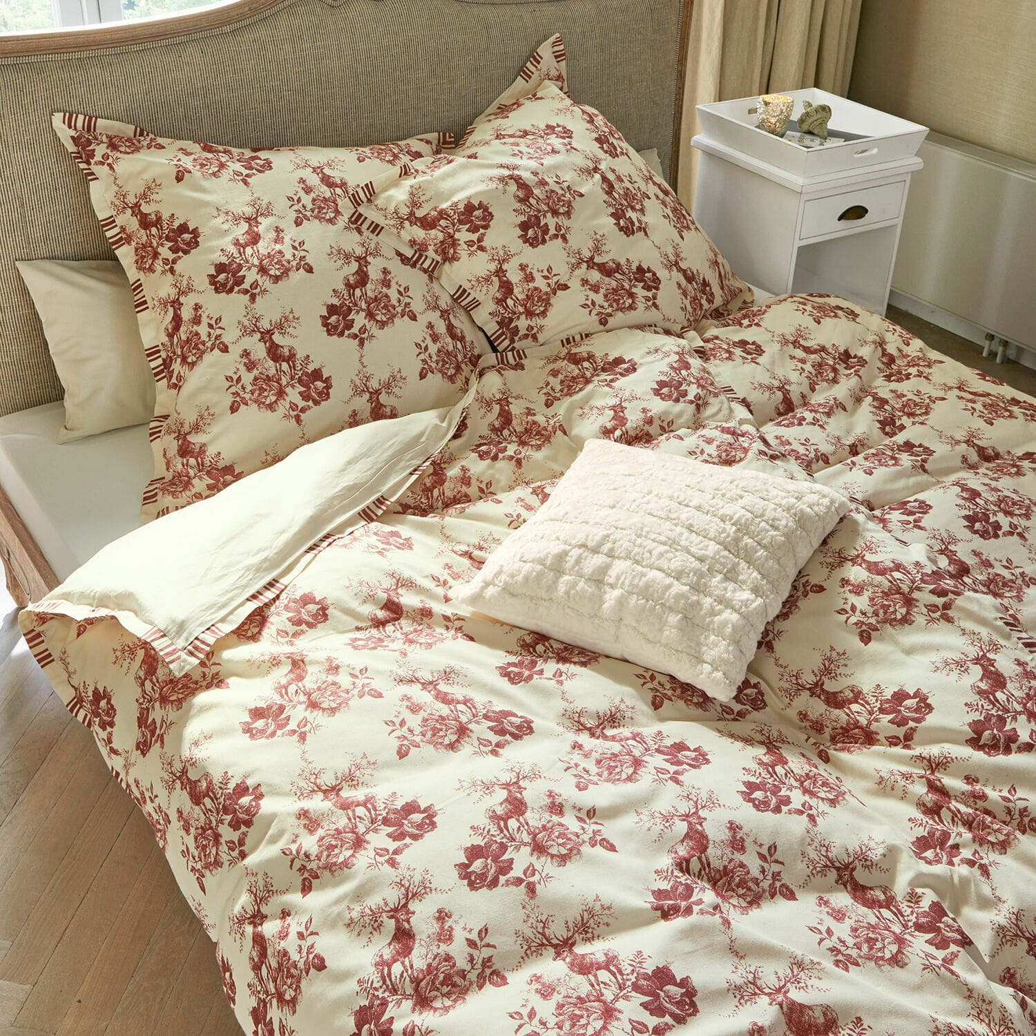 Parure de lit Renique Parure de lit en coton crème avec motif rouge de cerfs et fleurs, coussin décoratif sur le lit