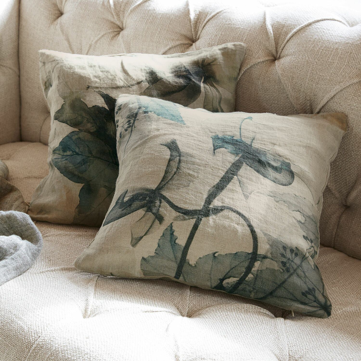 Lot de 2 housses de coussins Forsyth Coussins décoratifs en lin beige avec motifs de feuilles vertes sur un canapé clair