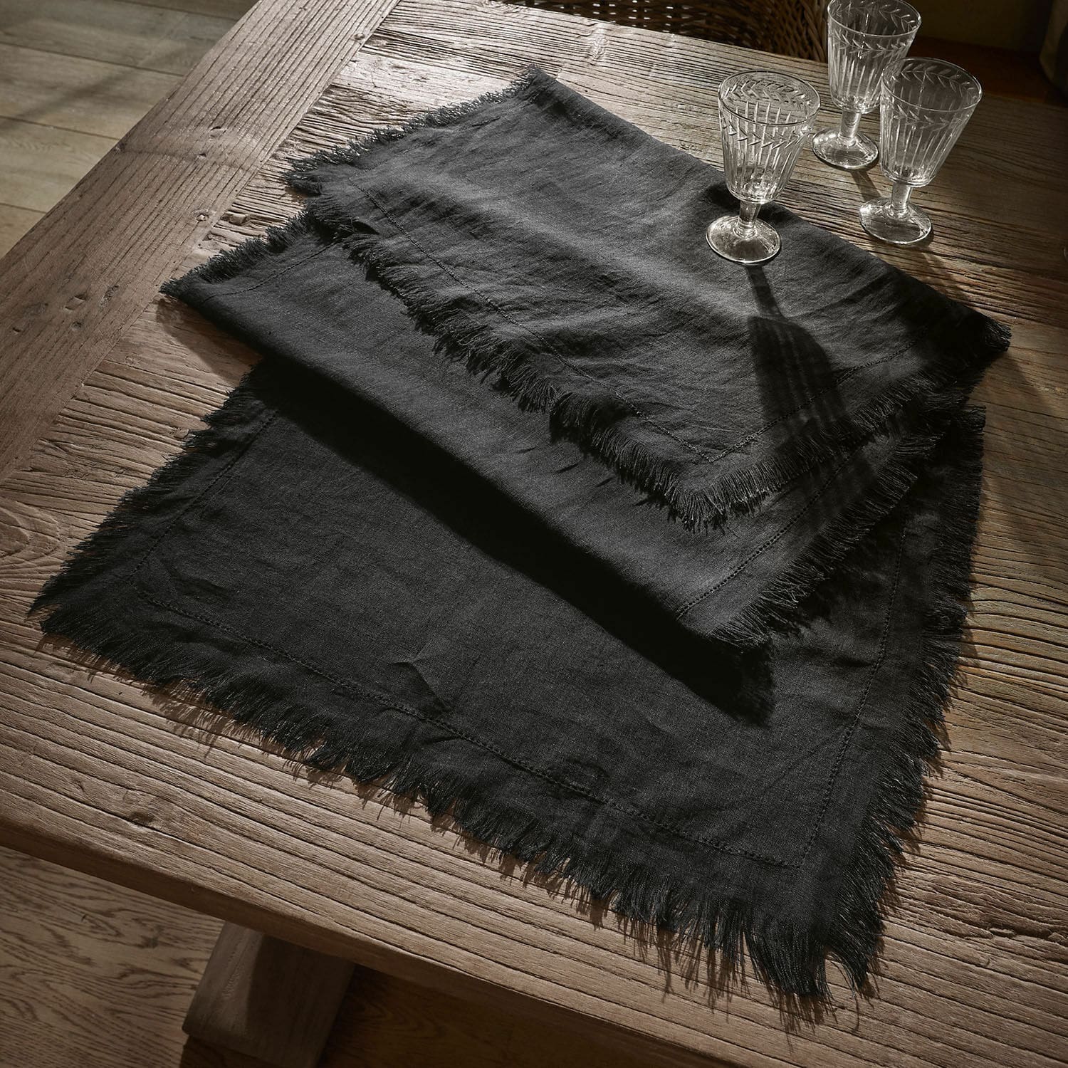 Chemin de table Pibrac Nappe noire en lin avec franges sur table en bois, décoration de table élégante
