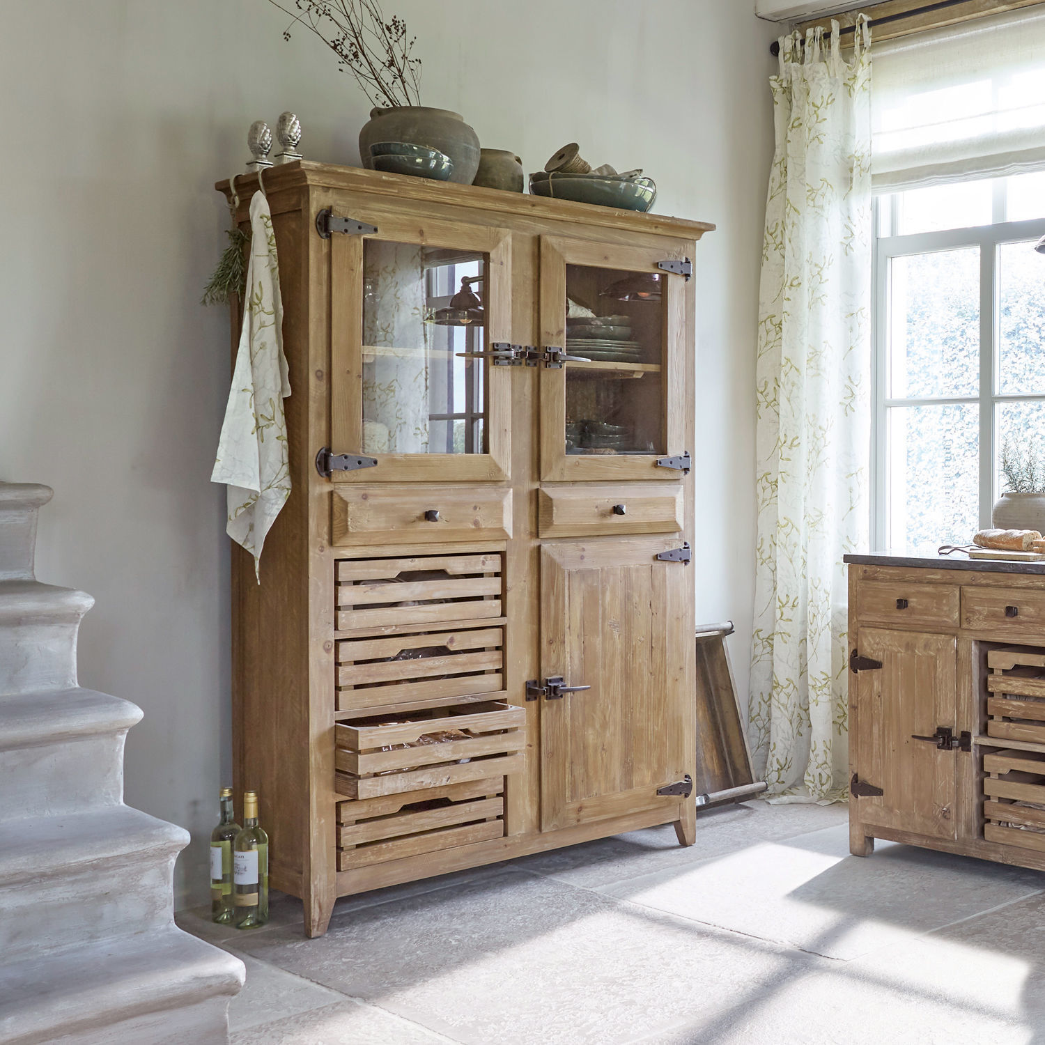 Buffet Stonehenge Buffet en bois clair avec tiroirs et portes vitrées dans une cuisine lumineuse